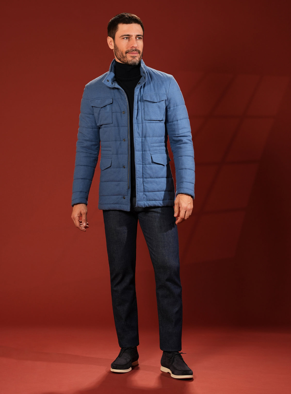 Blue quilted Consiglieri jacket with a dark turtleneck and trousers