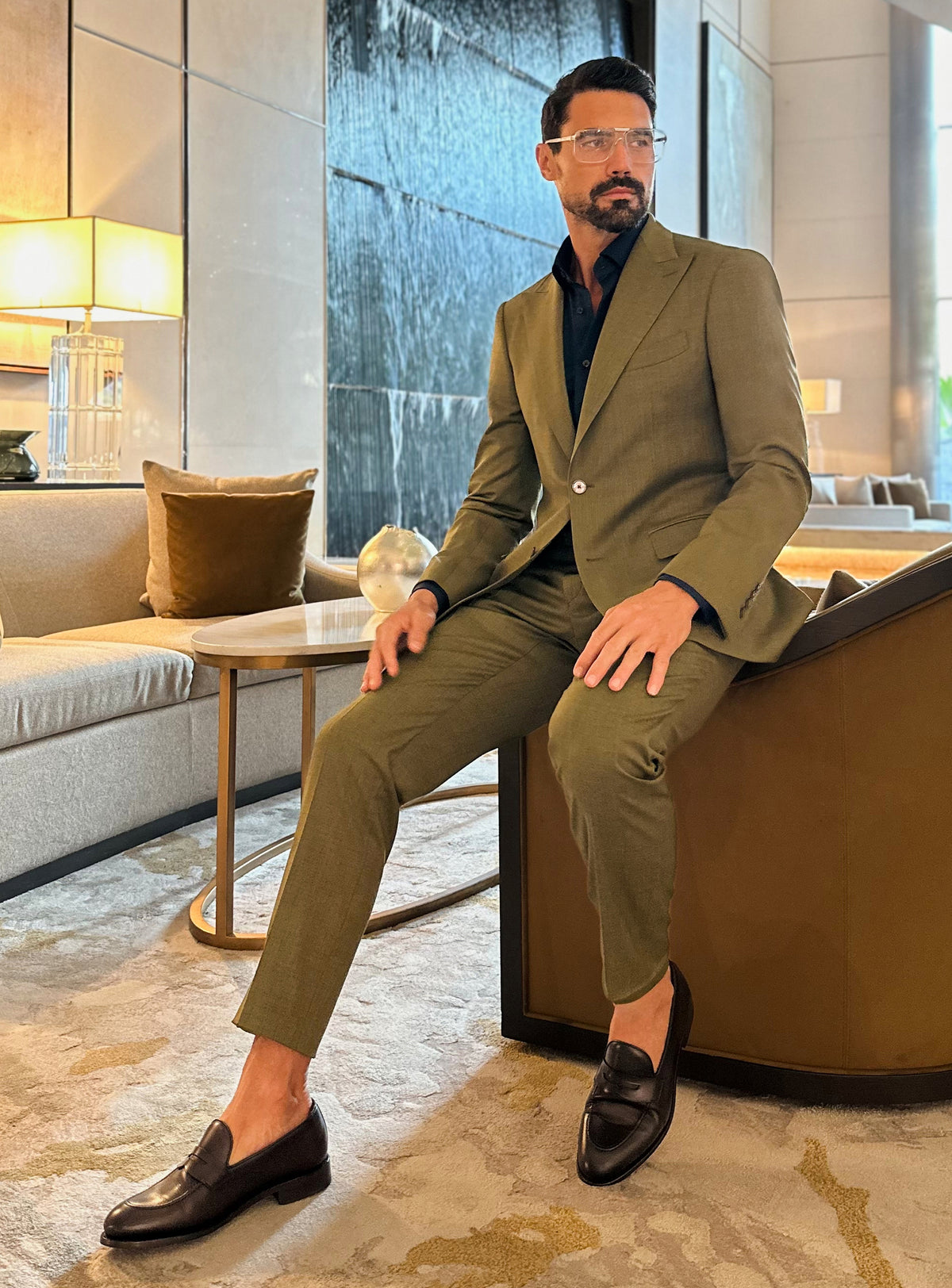 Olive green Consiglieri suit in a relaxed seated look in a lounge