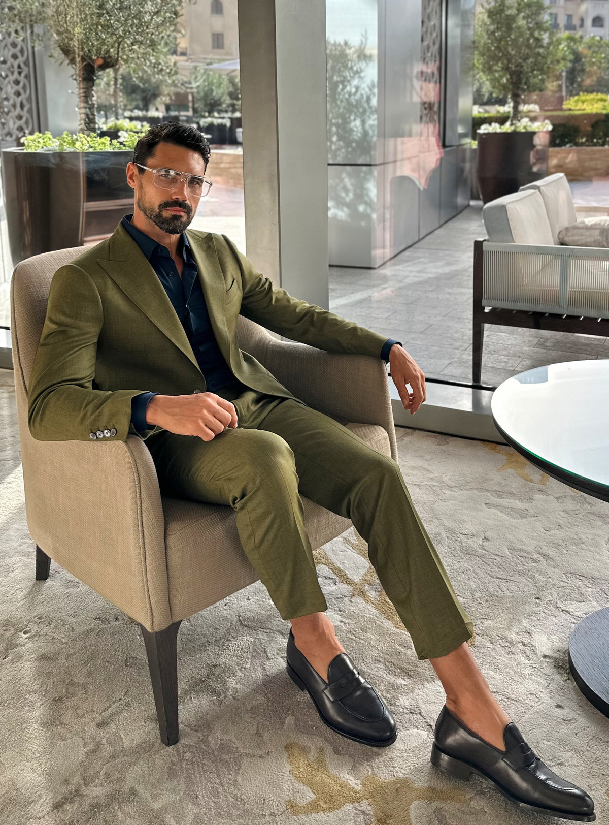 Olive green Consiglieri suit in a relaxed seated look in a lounge
