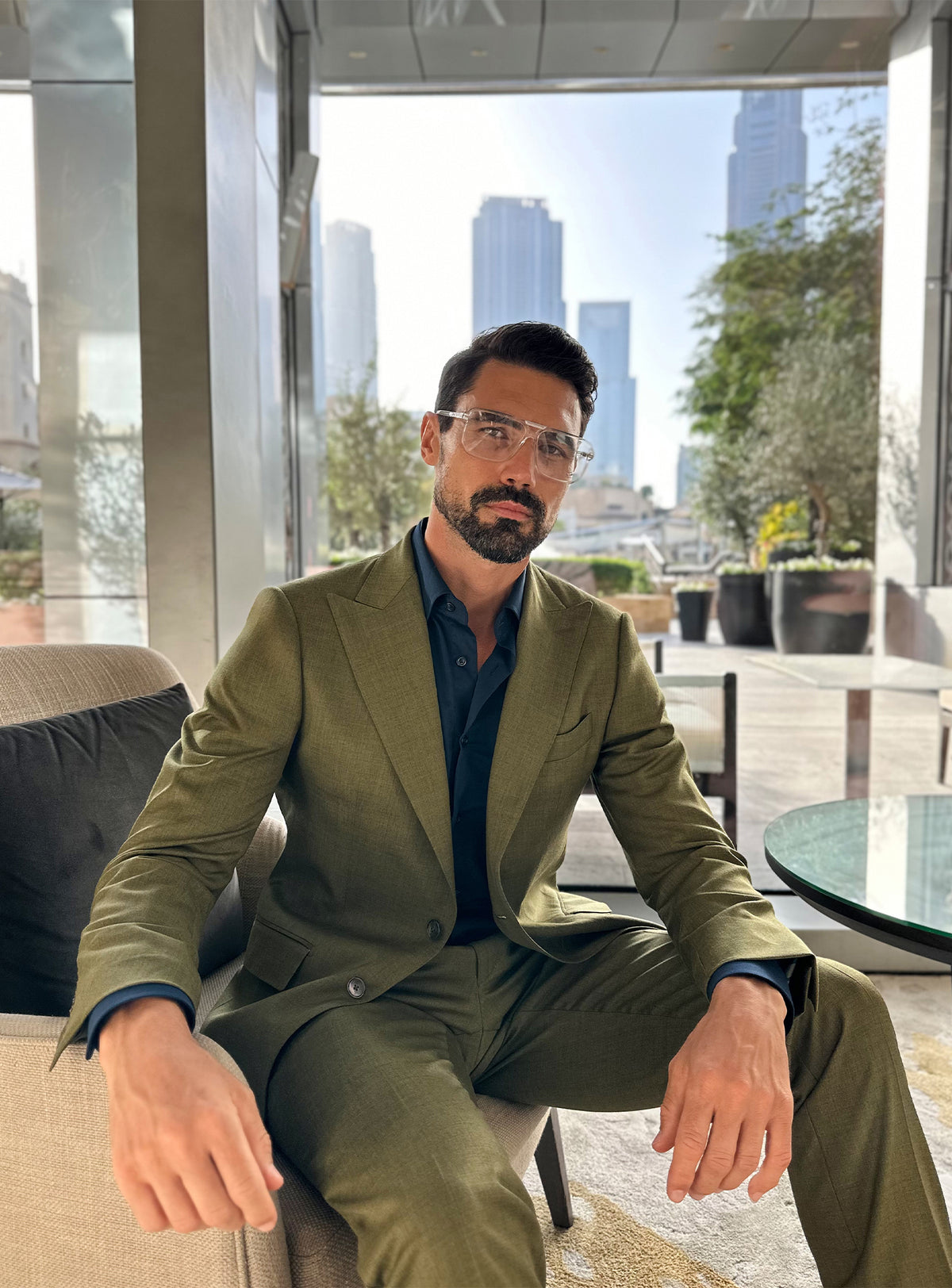Olive green Consiglieri suit in a relaxed seated look in a lounge