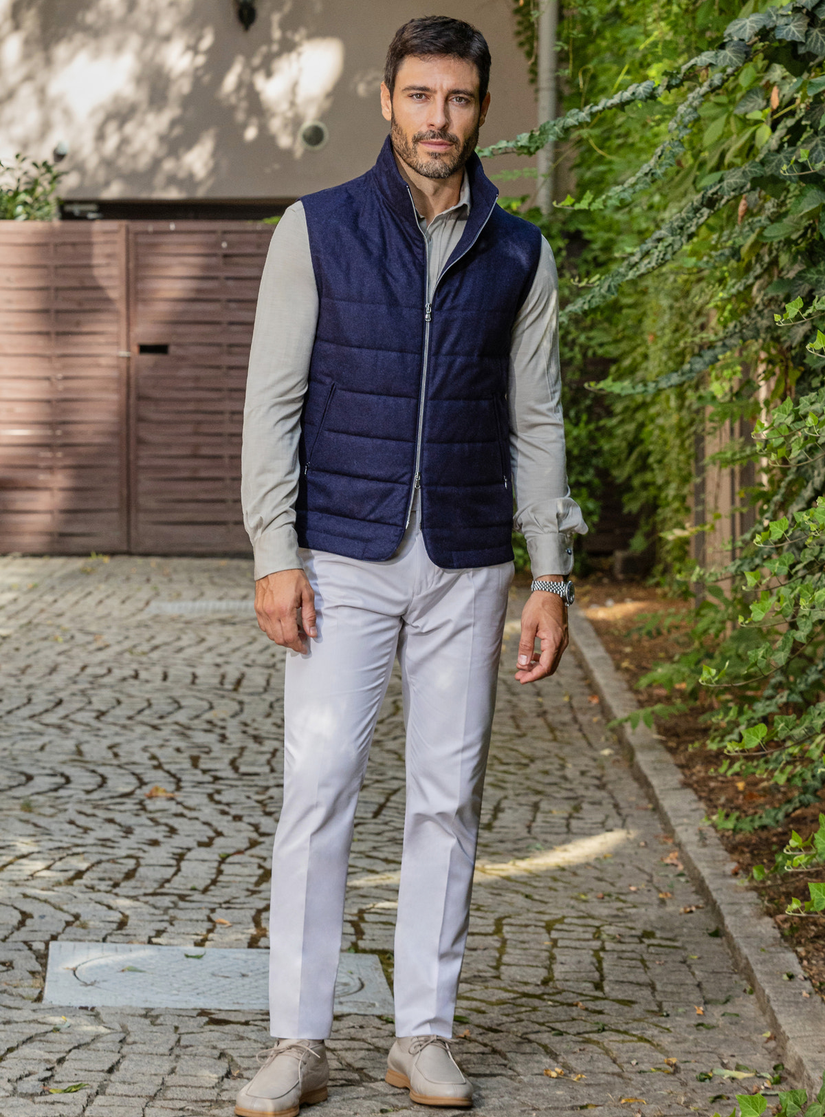 Consiglieri: navy quilted gilet over a grey shirt, with light trousers