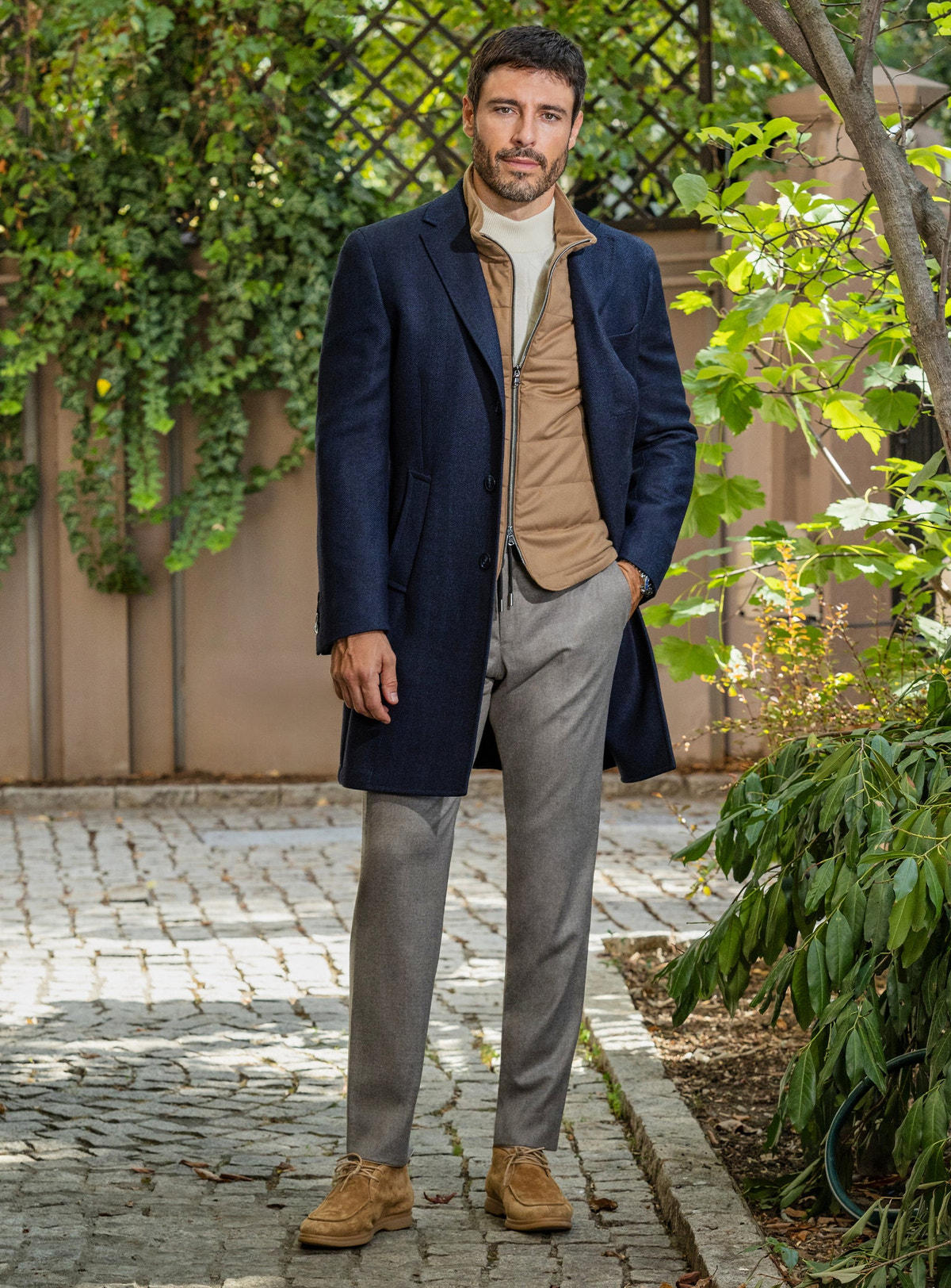 Consiglieri: camel gilet beneath a navy overcoat, with grey trousers