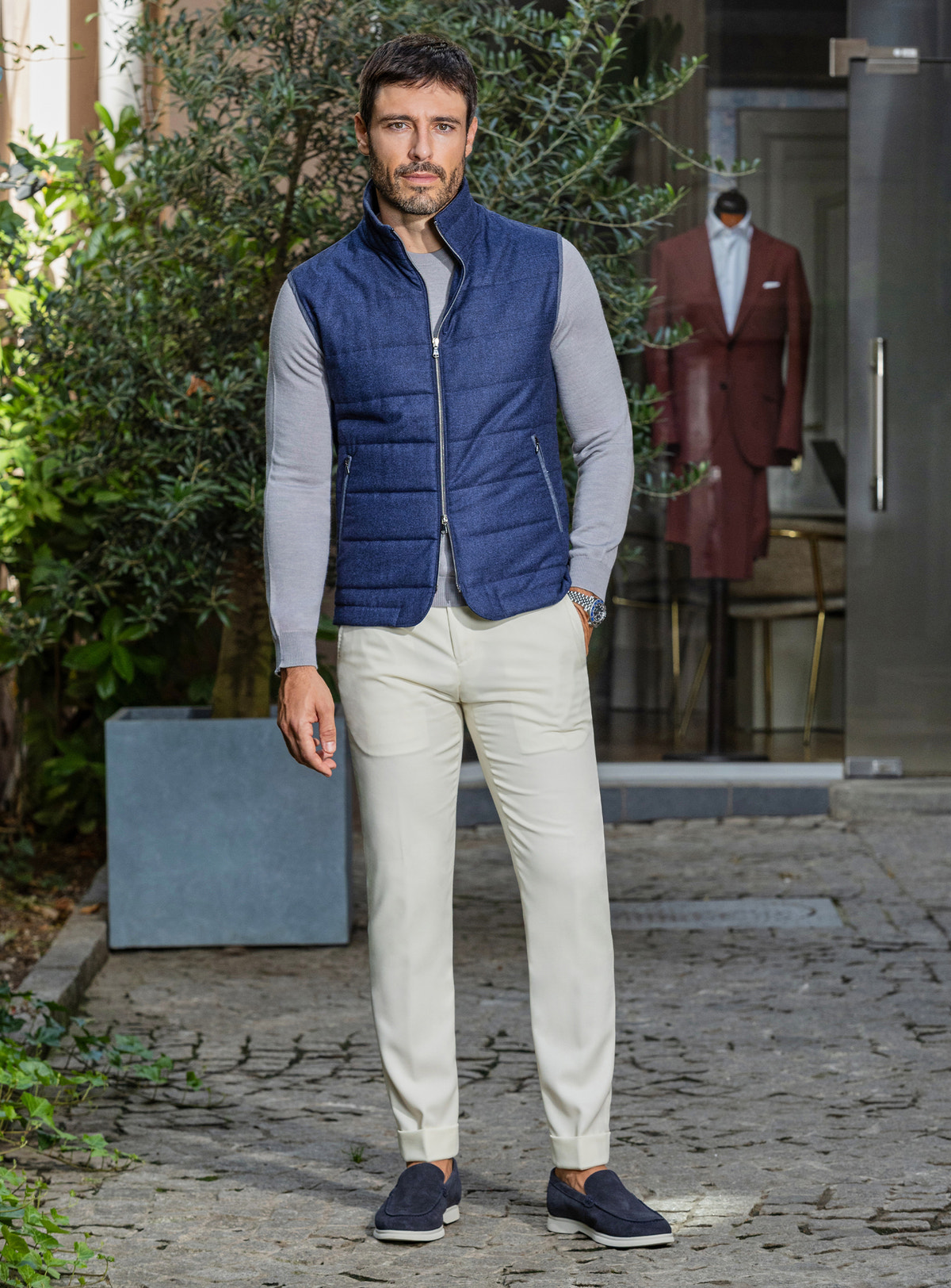 Consiglieri: blue quilted gilet over a grey shirt, with cream trousers