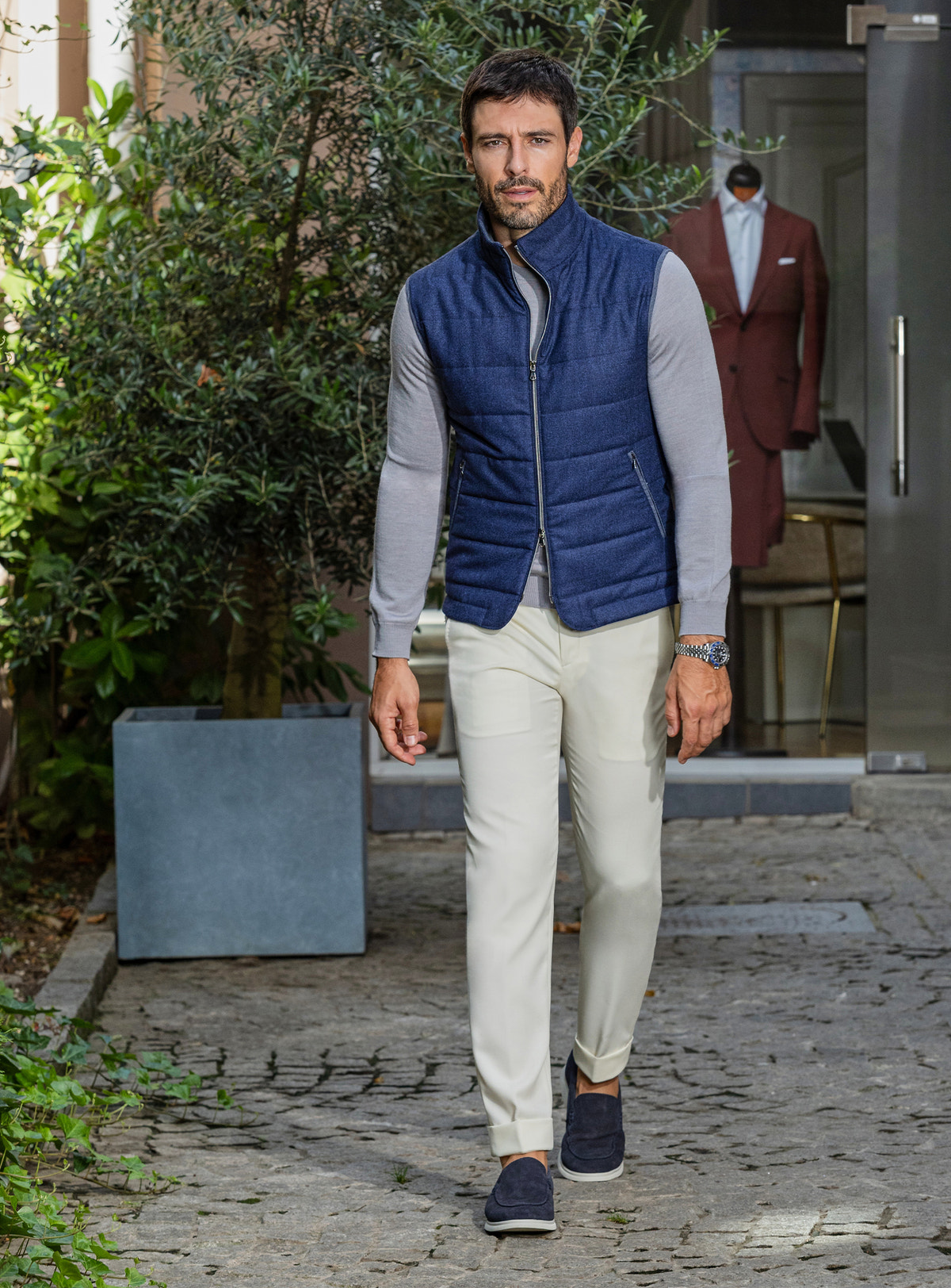 Consiglieri: blue quilted gilet over a grey shirt, with cream trousers