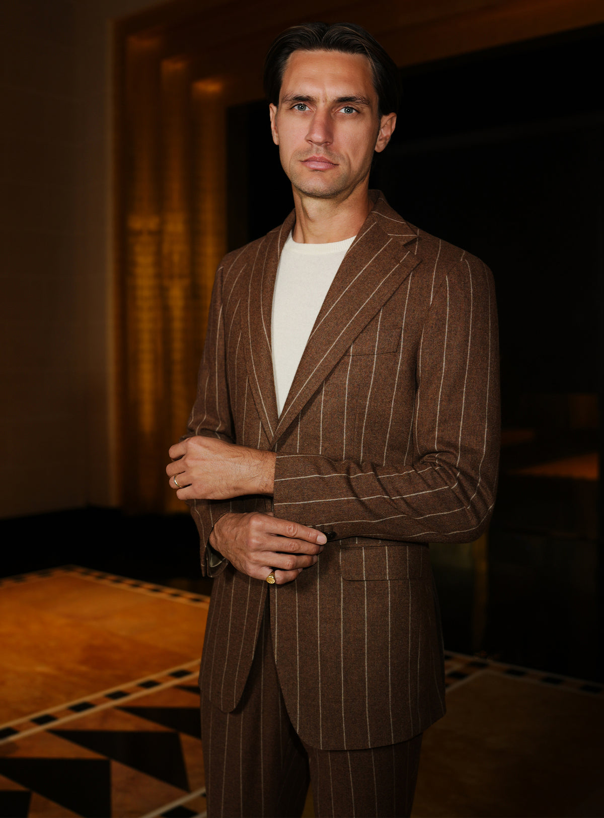 Brown double-breasted jacket with light stripes and an ivory sweater