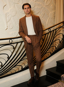Brown Consiglieri suit with light stripes, worn with an ivory sweater