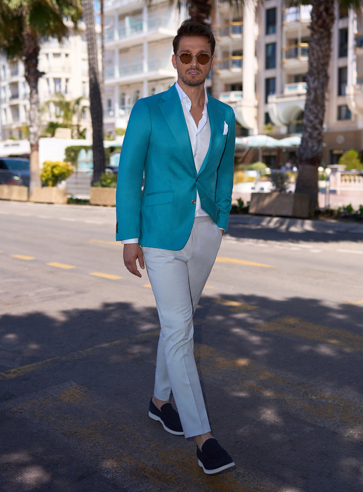 Consiglieri look with a turquoise jacket, white trousers and dark loafers