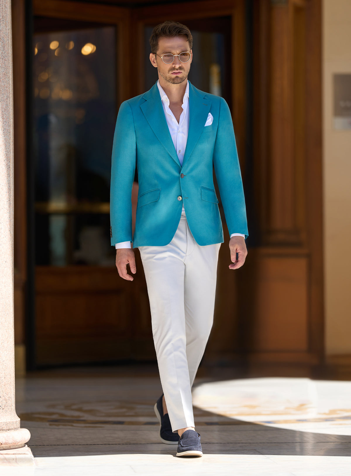 Consiglieri look with a turquoise jacket, white trousers and dark loafers