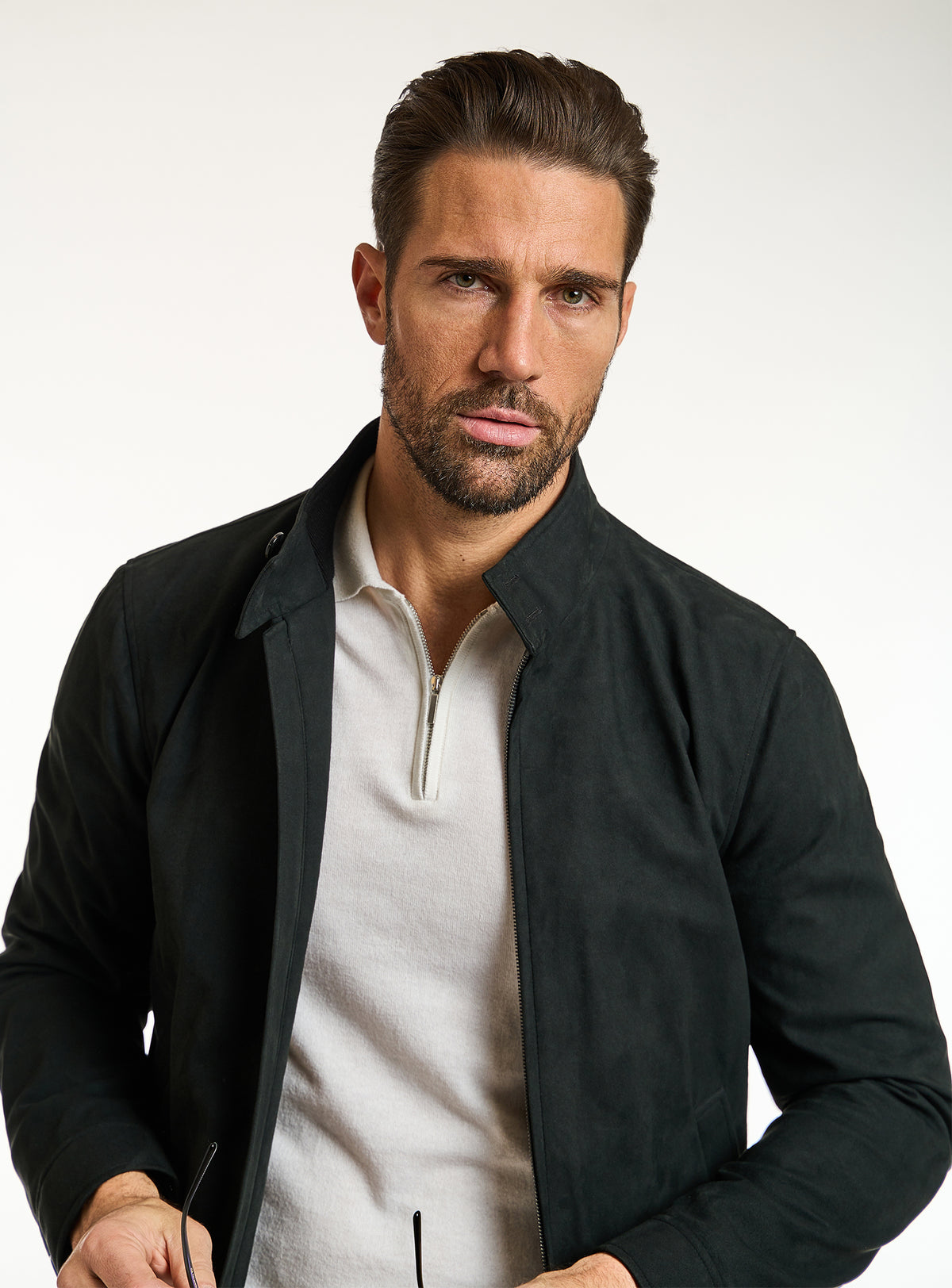 Consiglieri: dark green zip-front jacket with an ivory polo and beige trousers