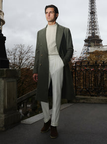 Long olive green Consiglieri overcoat with a light turtleneck and white trousers