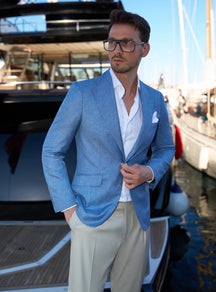Pale blue Consiglieri jacket worn with a white shirt beside a yacht