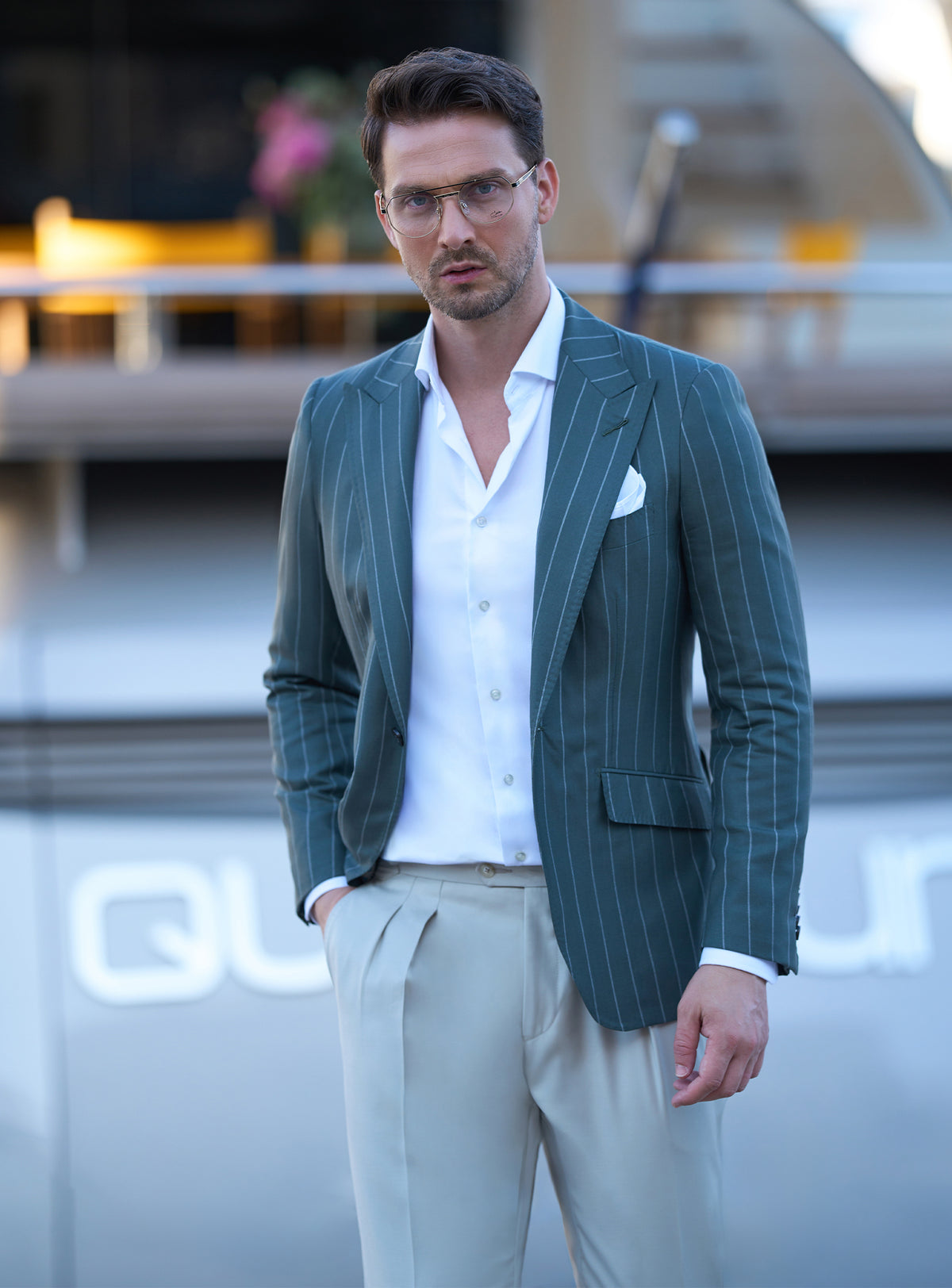 Dark green pinstripe jacket worn with a white shirt and beige trousers