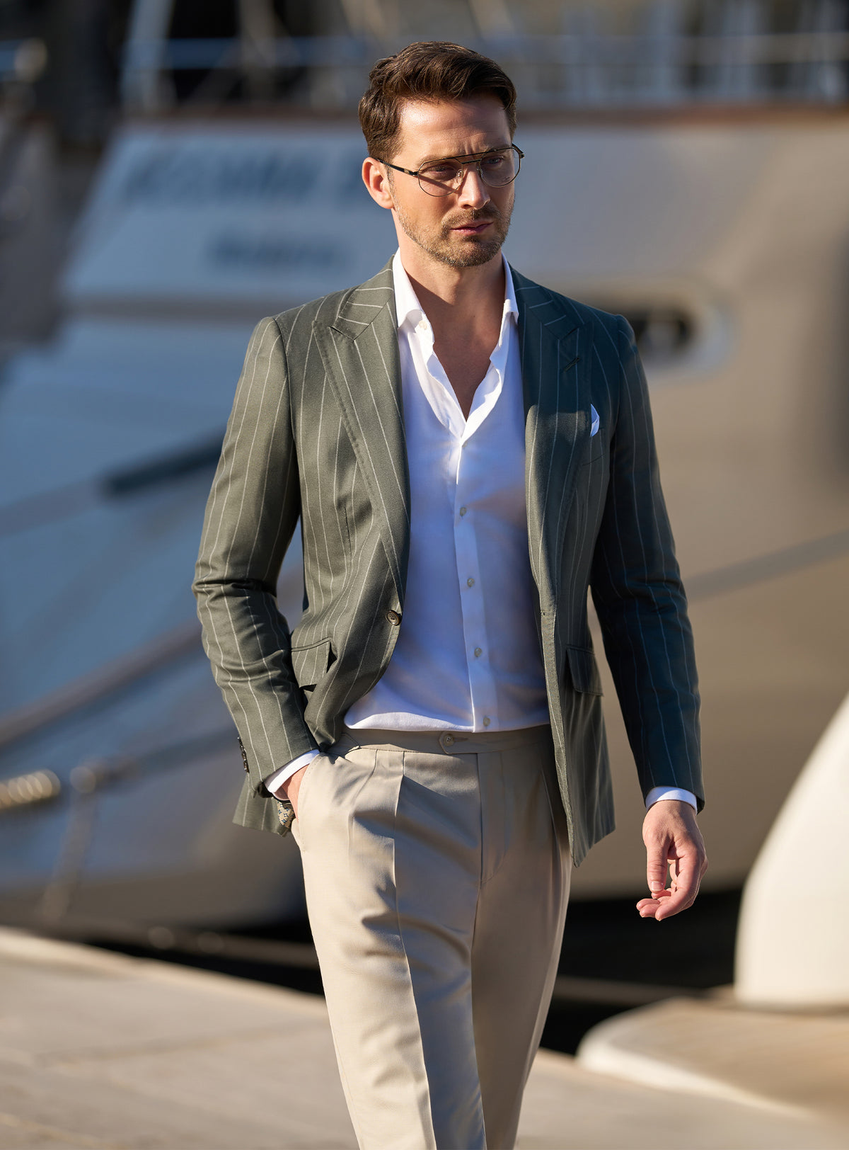 Dark green pinstripe jacket worn with a white shirt and beige trousers