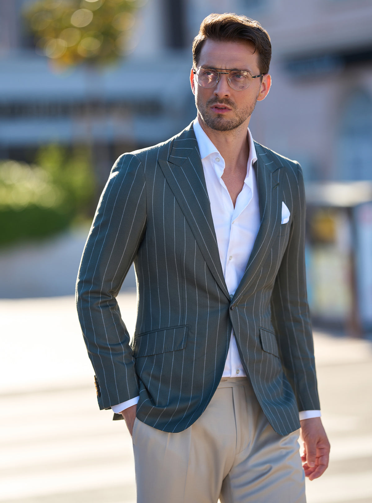 Dark green pinstripe jacket worn with a white shirt and beige trousers