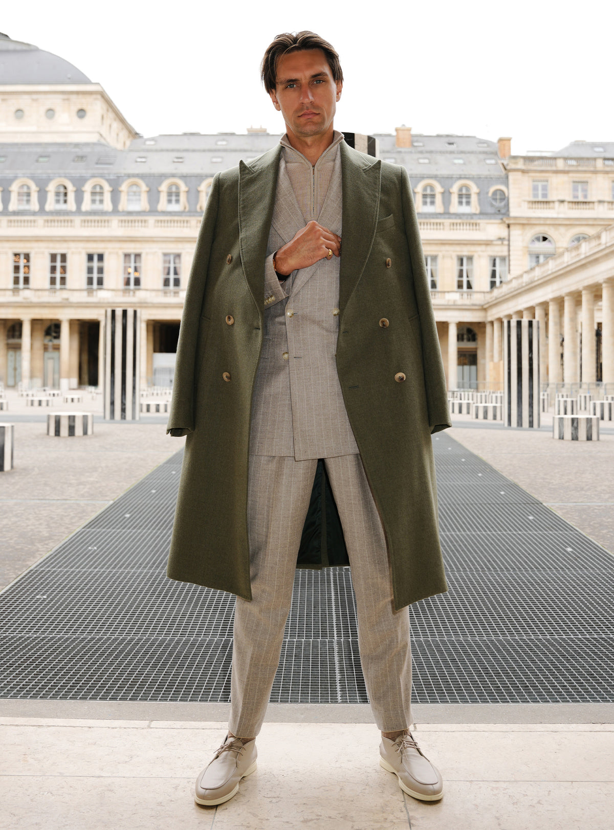 Long olive green Consiglieri overcoat with a double-breasted front and light trousers