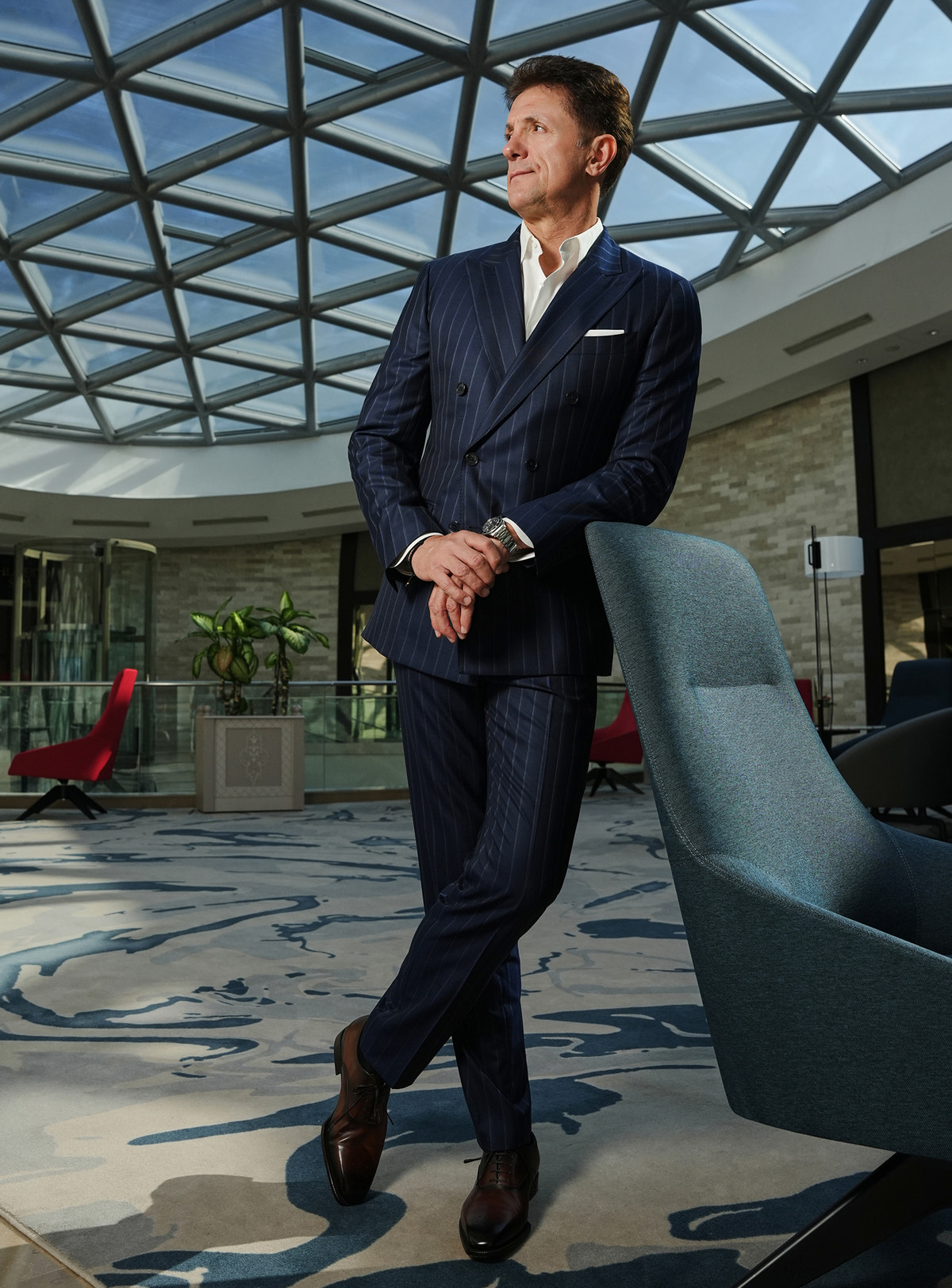 Navy pinstripe Consiglieri suit in a look with brown shoes