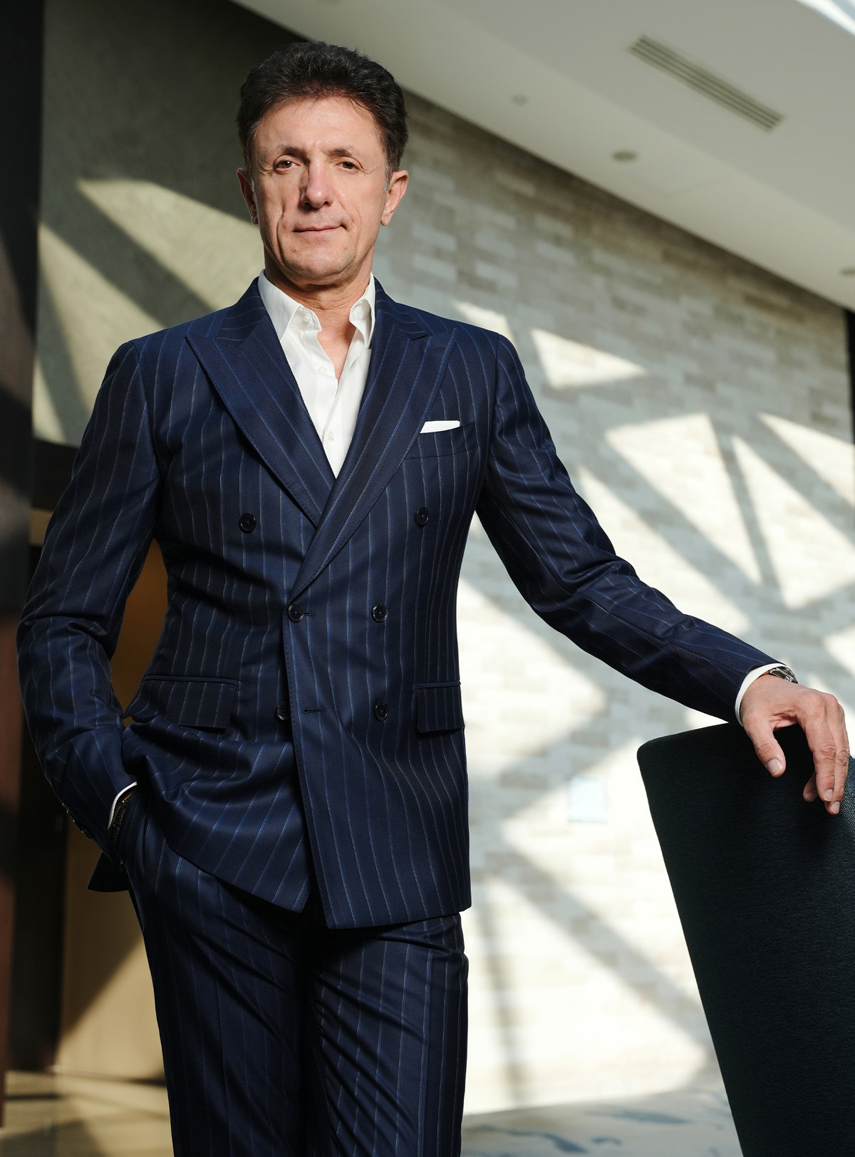 Navy pinstripe double-breasted jacket with a white pocket square