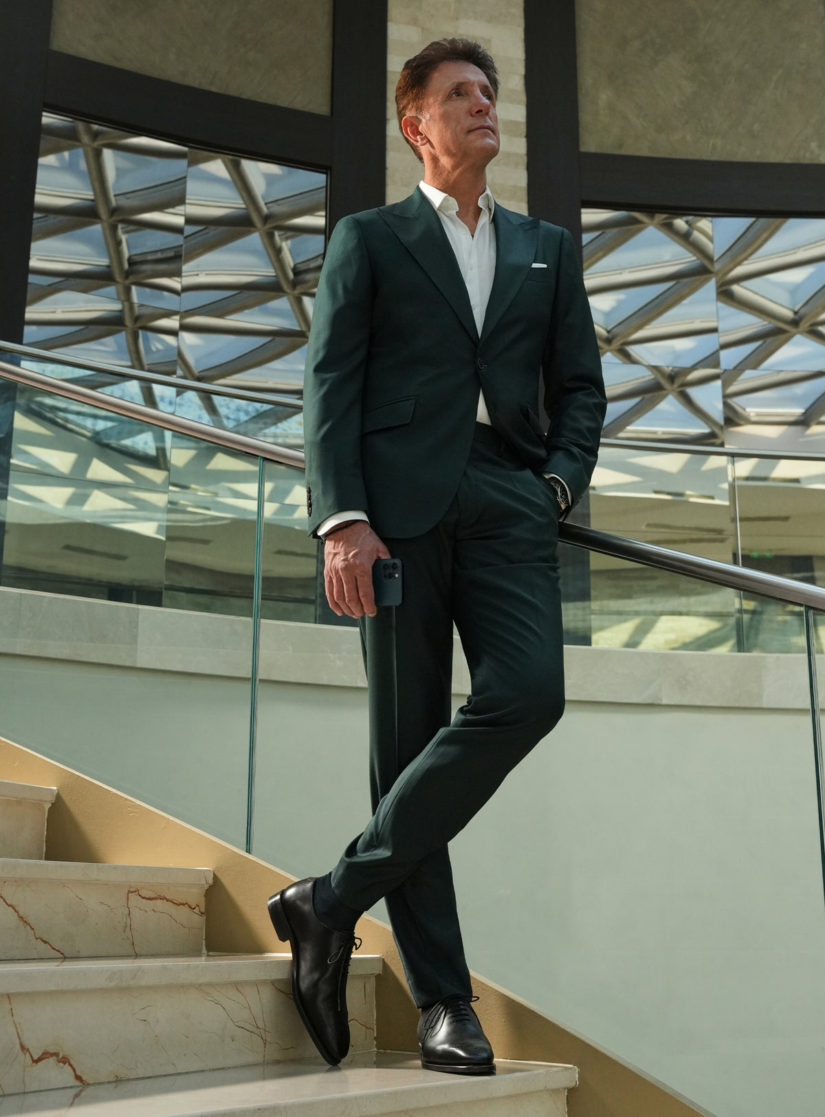 Dark green Consiglieri suit with a white shirt and black shoes