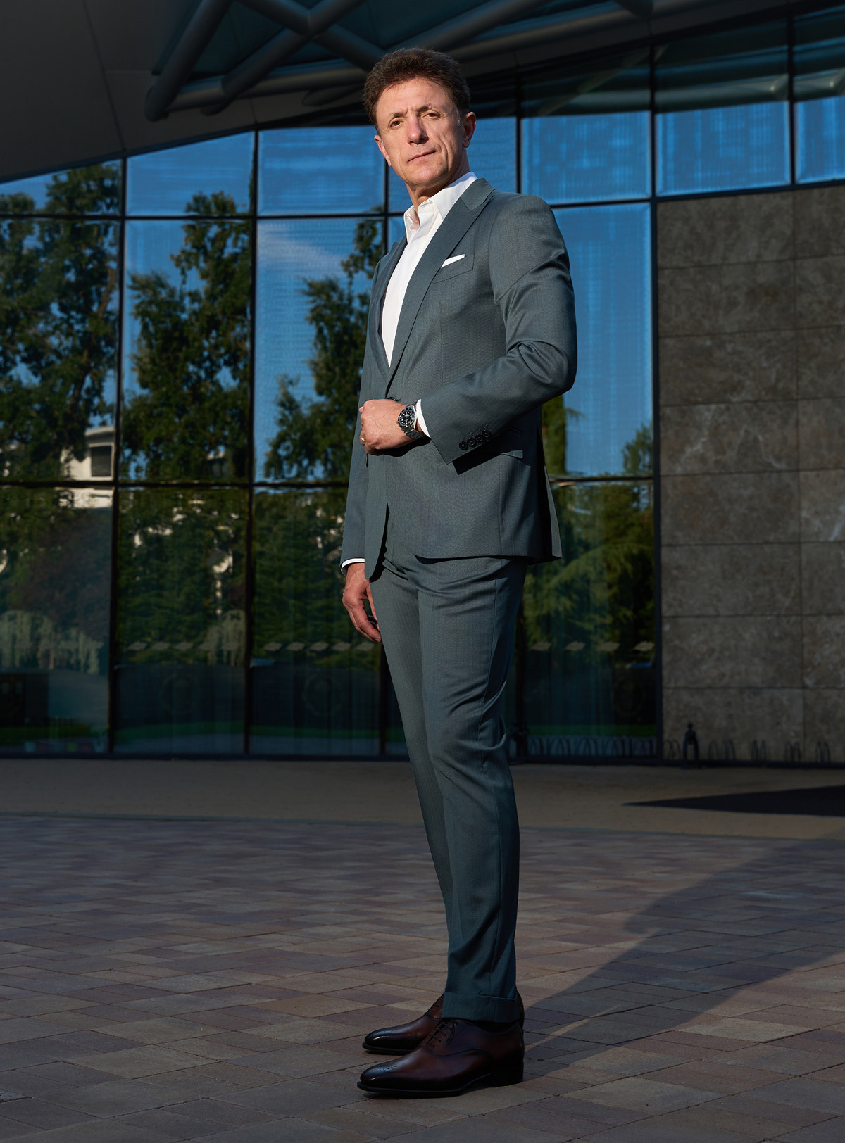 Grey-green Consiglieri suit in a complete look with brown shoes