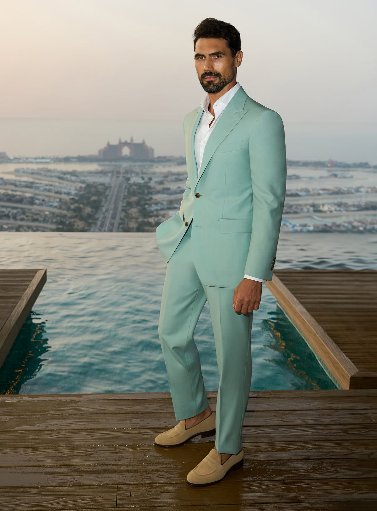 Consiglieri Sapphire Sophistication: mint green suit with a white shirt beside a pool
