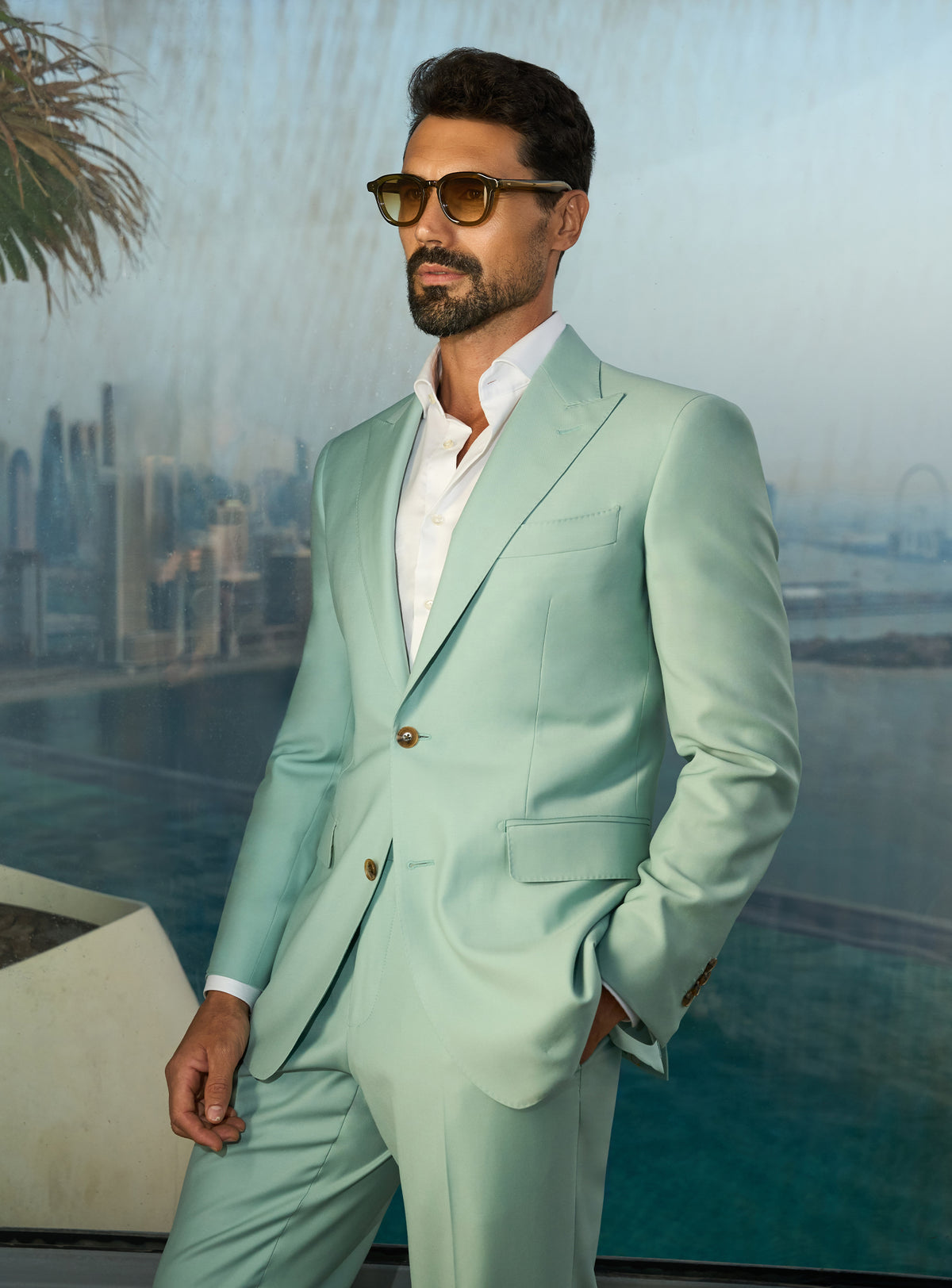Consiglieri Sapphire Sophistication: mint green suit with a white shirt beside a pool