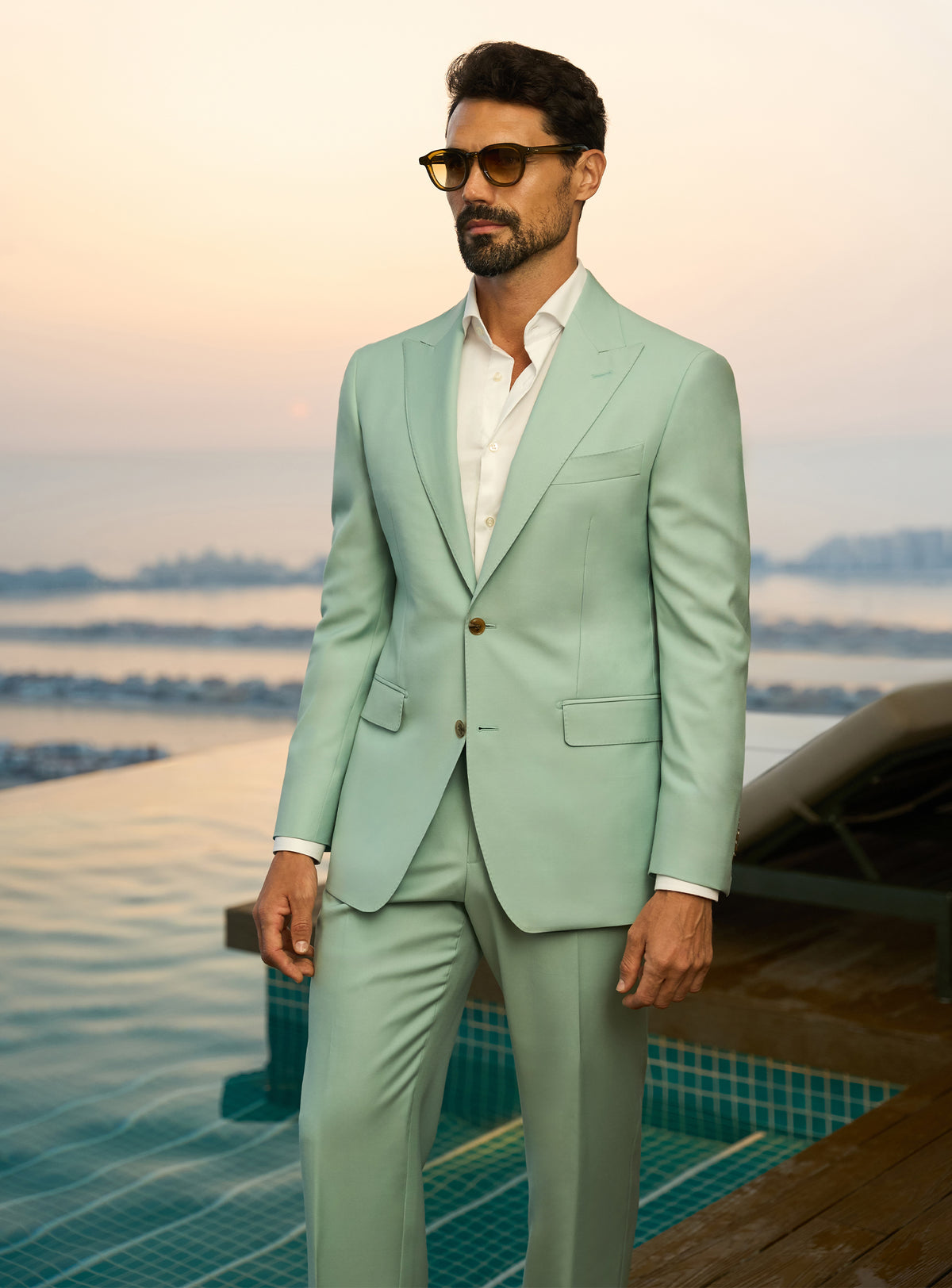 Consiglieri Sapphire Sophistication: mint green suit with a white shirt beside a pool