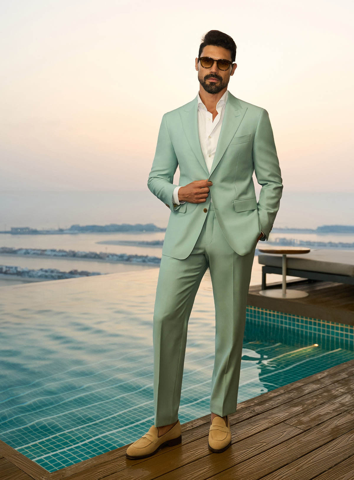 Consiglieri Sapphire Sophistication: mint green suit with a white shirt beside a pool