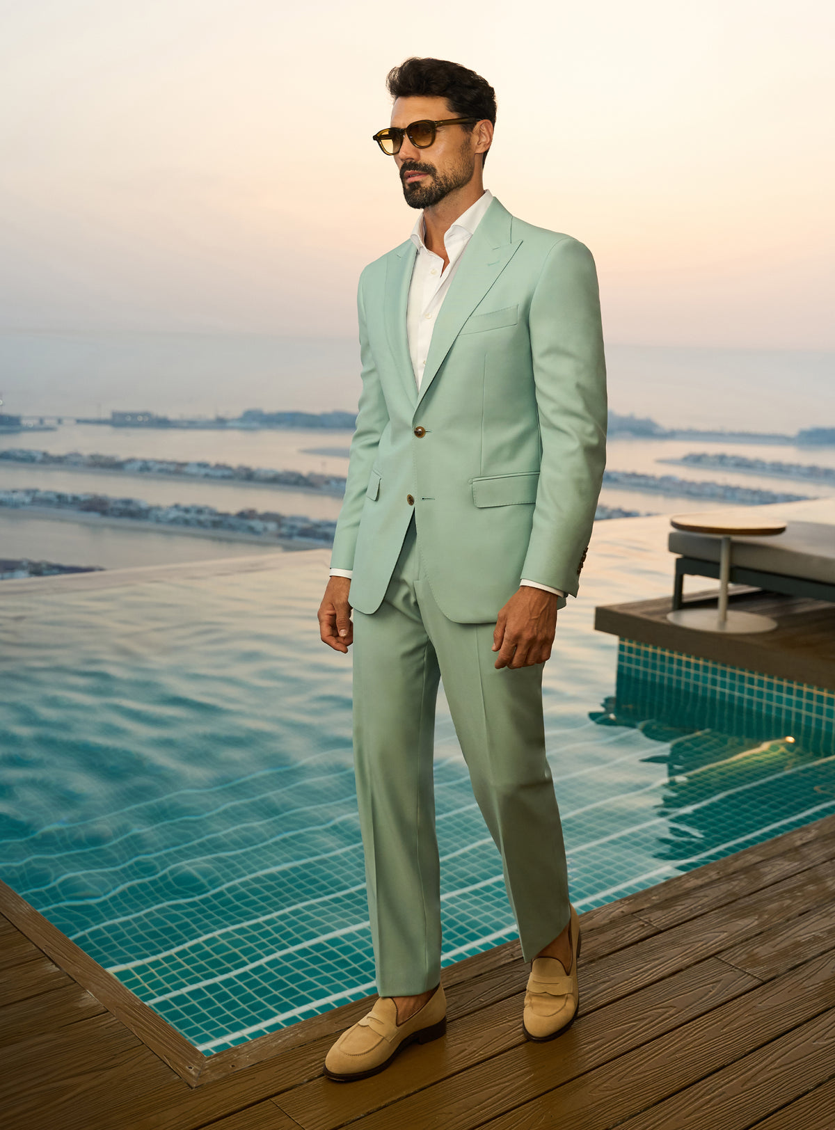 Consiglieri Sapphire Sophistication: mint green suit with a white shirt beside a pool
