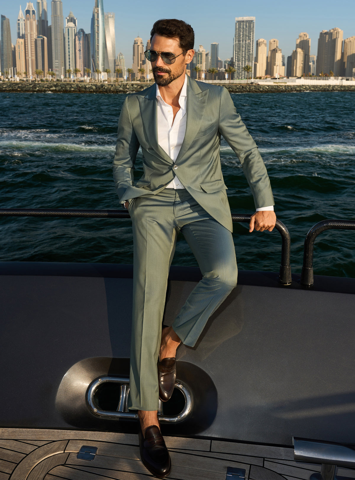 Consiglieri Solaris Essence: sage green suit with a white shirt, worn on a yacht deck