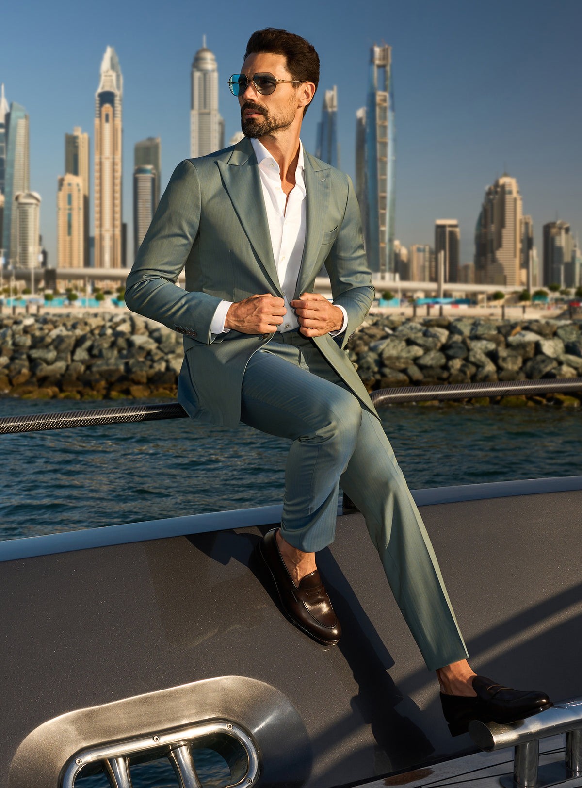 Consiglieri Solaris Essence: sage green suit with a white shirt, worn on a yacht deck