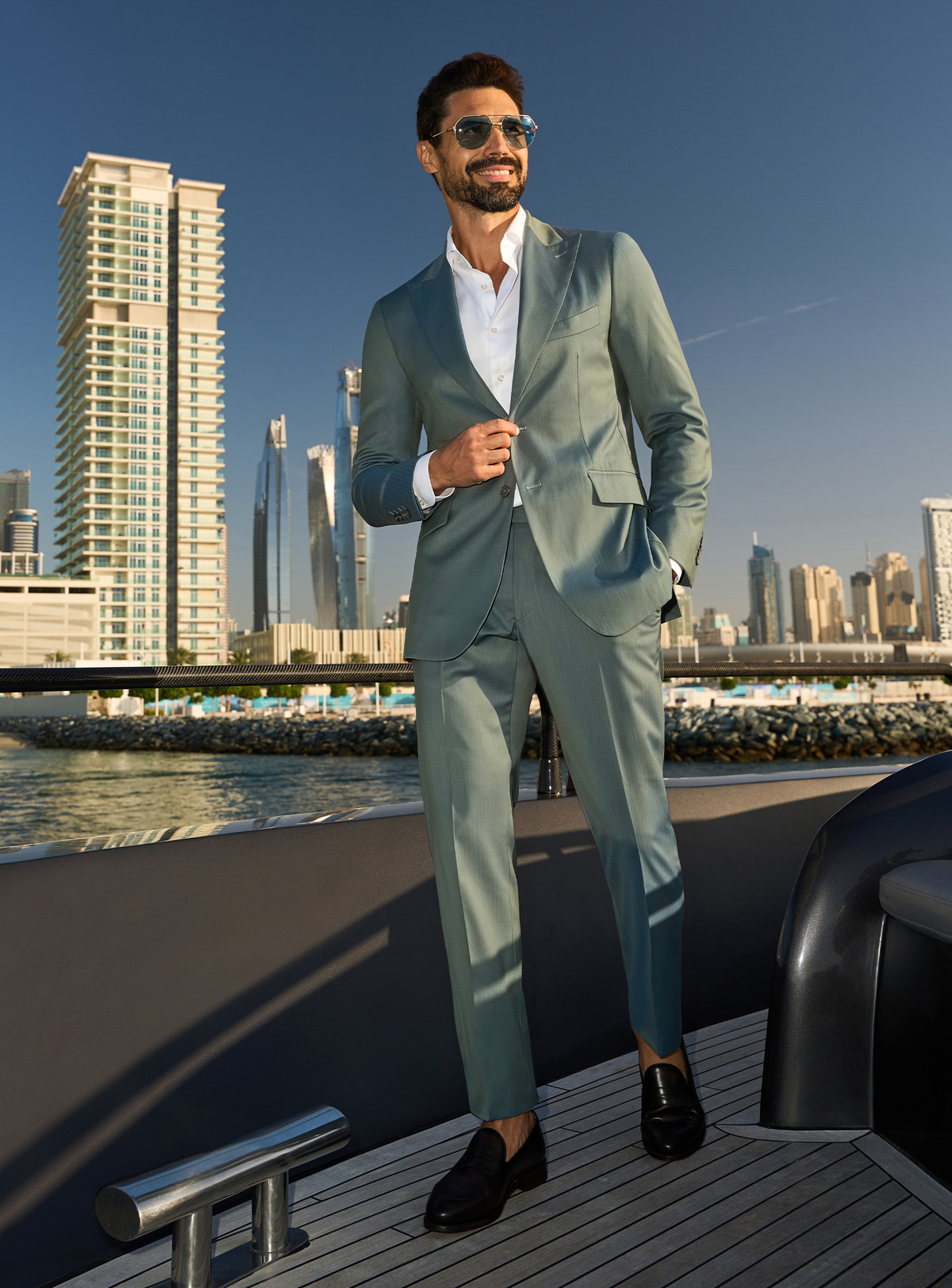 Consiglieri Solaris Essence: sage green suit with a white shirt, worn on a yacht deck