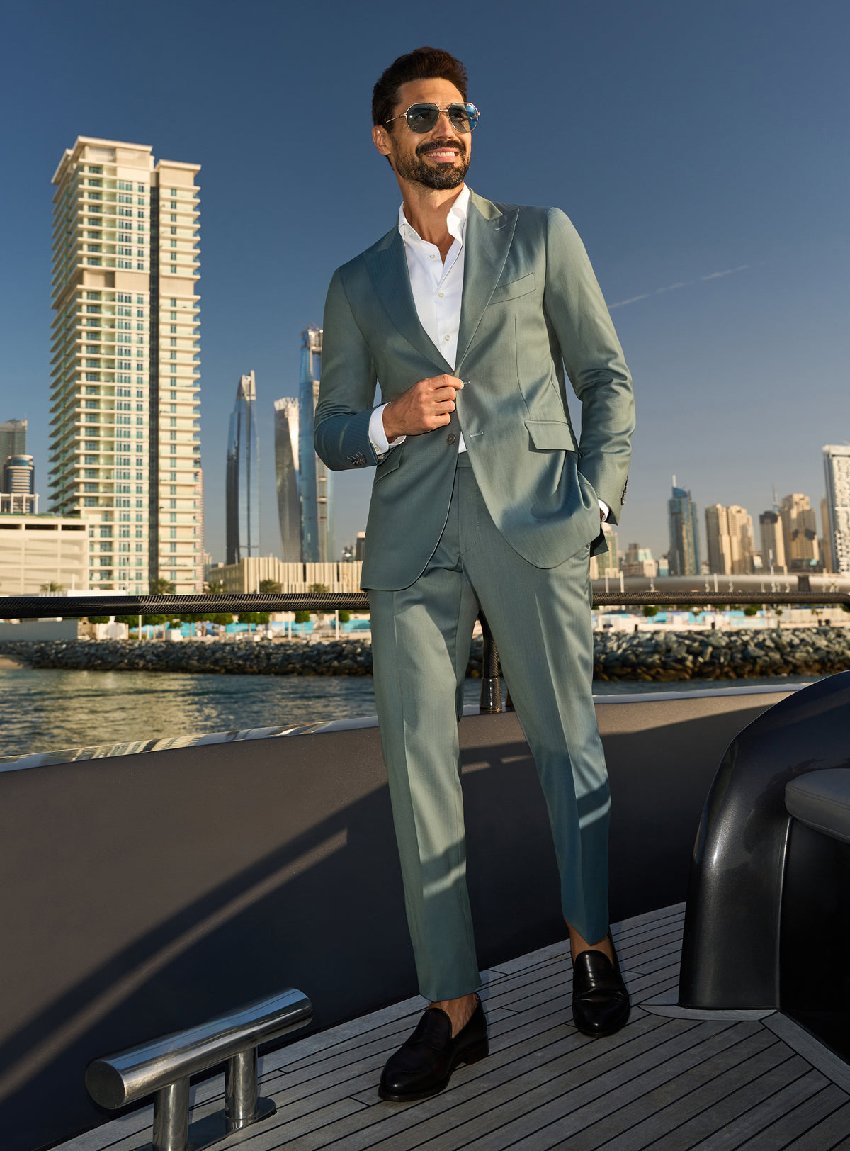 Consiglieri Solaris Essence: sage green suit with a white shirt, worn on a yacht deck