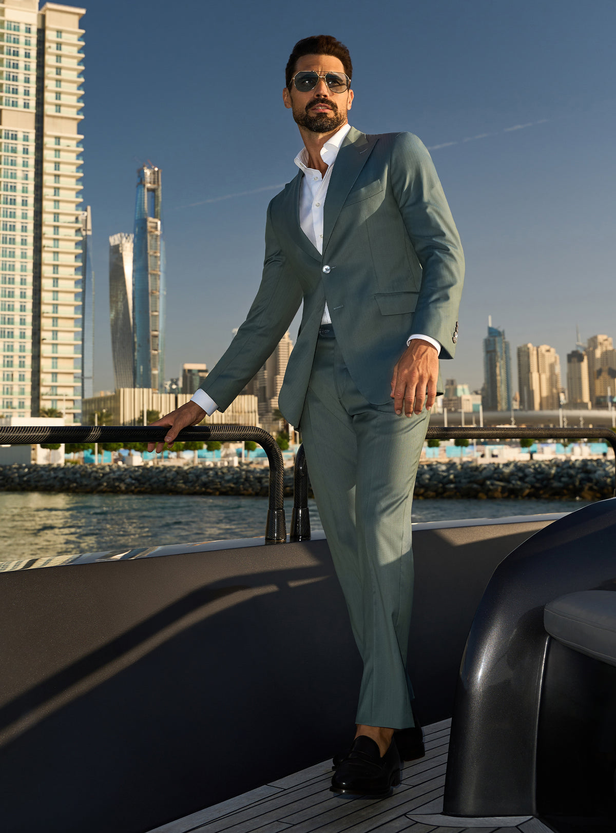 Consiglieri Solaris Essence: sage green suit with a white shirt, worn on a yacht deck