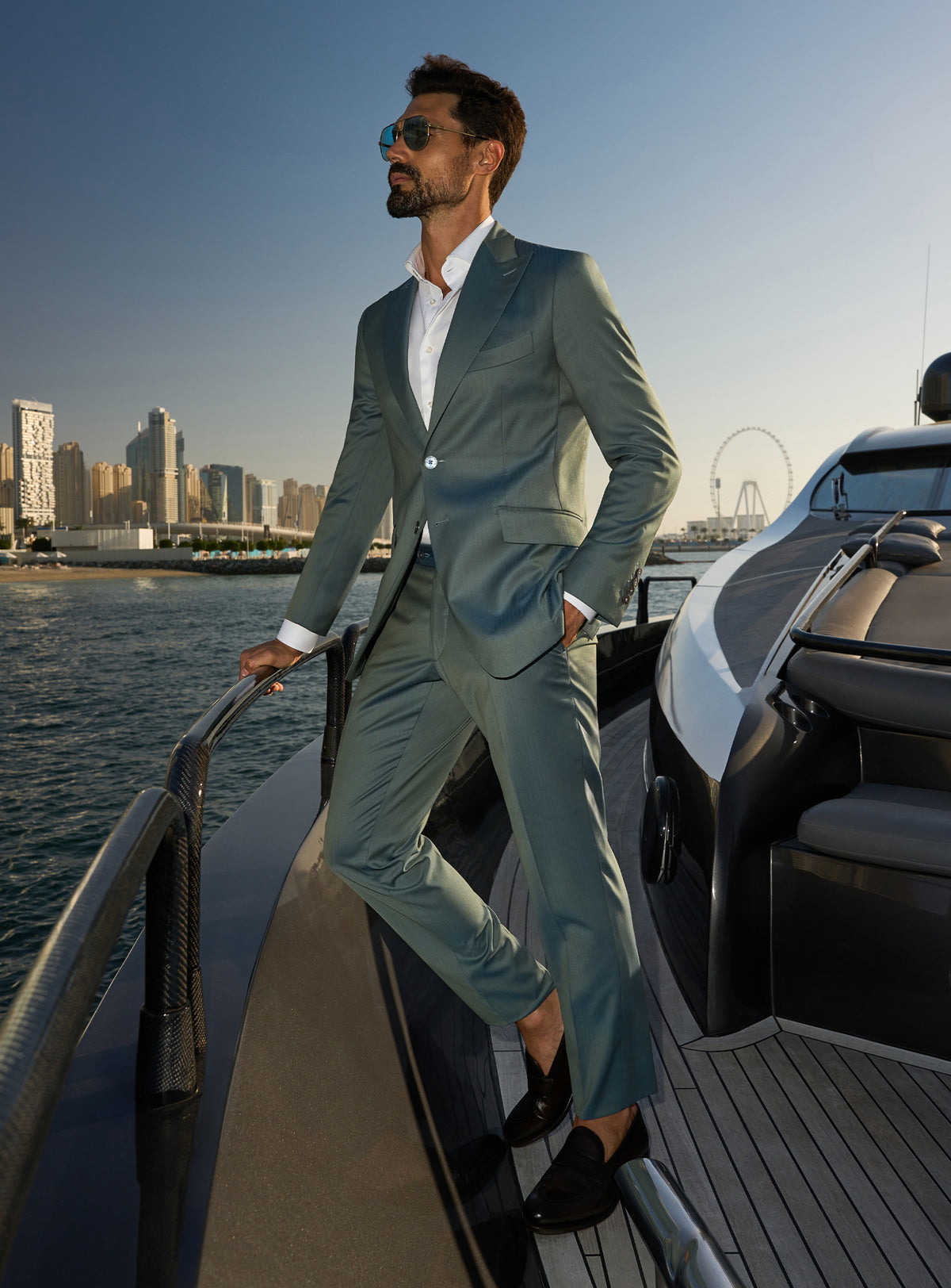 Consiglieri Solaris Essence: sage green suit with a white shirt, worn on a yacht deck