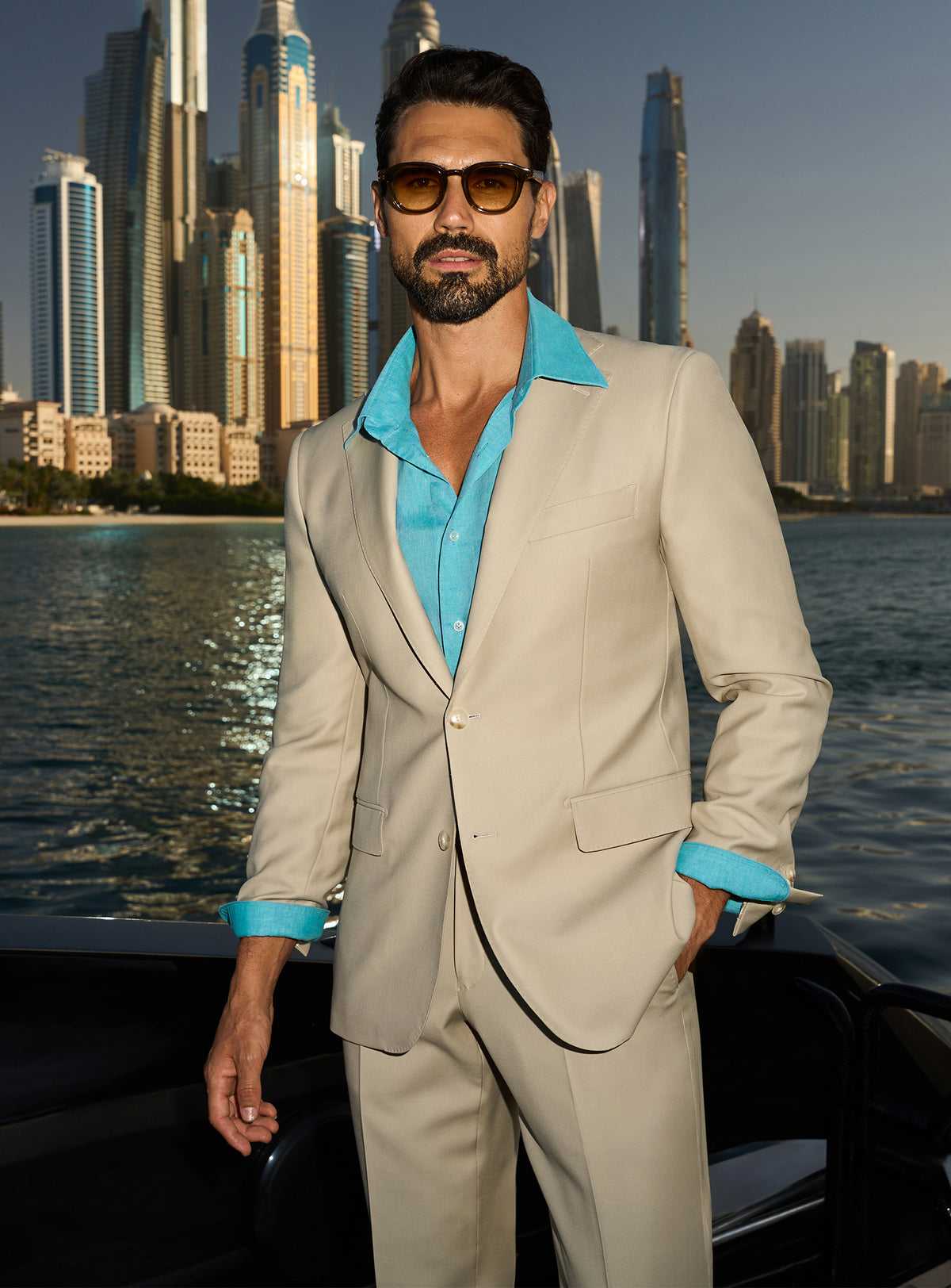 Consiglieri Splendor Radiance: cream suit with a turquoise shirt, worn on a yacht deck