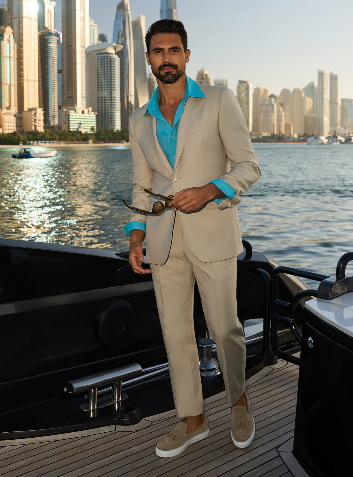 Consiglieri Splendor Radiance: cream suit with a turquoise shirt, worn on a yacht deck