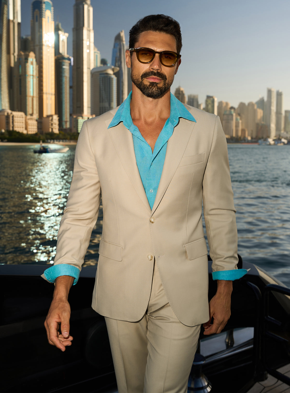 Consiglieri Splendor Radiance: cream suit with a turquoise shirt, worn on a yacht deck