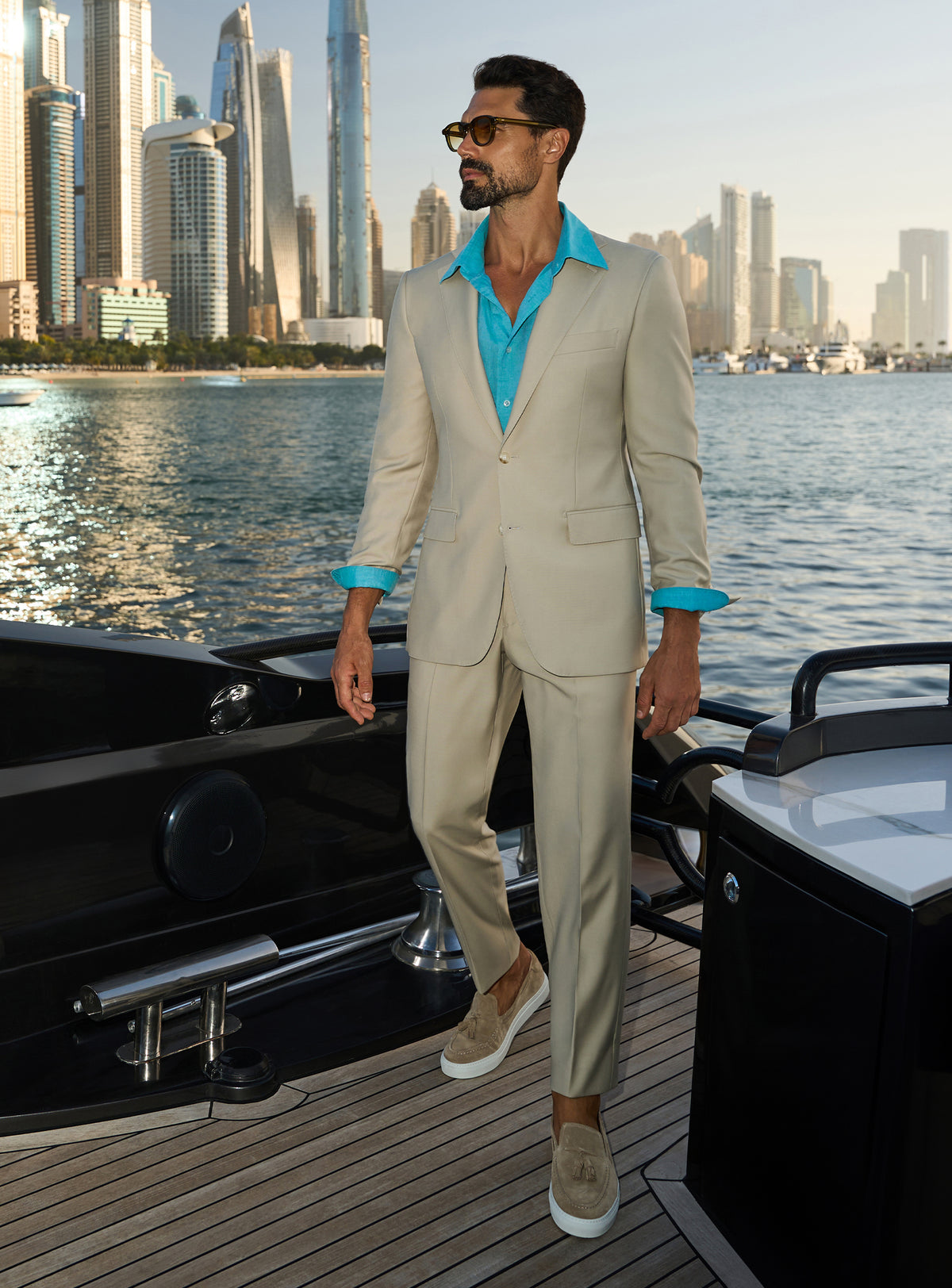 Consiglieri Splendor Radiance: cream suit with a turquoise shirt, worn on a yacht deck