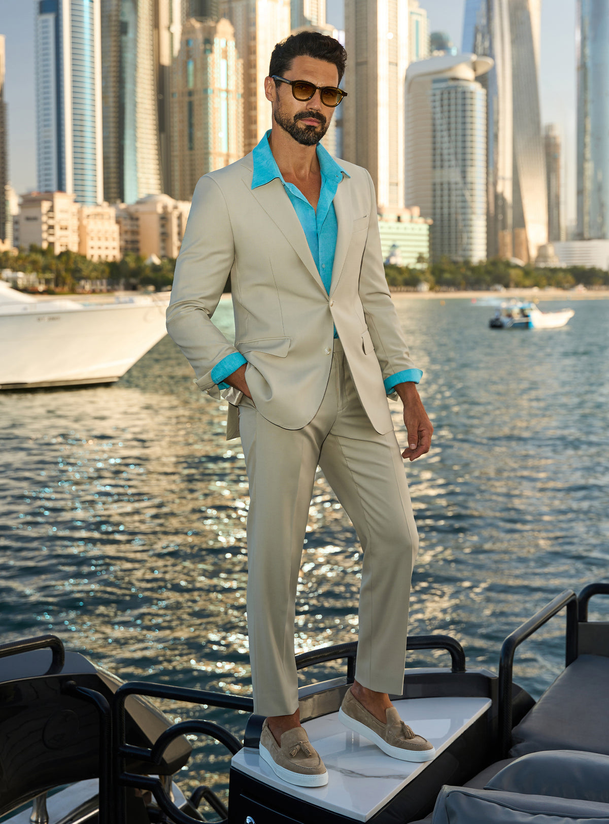 Consiglieri Splendor Radiance: cream suit with a turquoise shirt, worn on a yacht deck