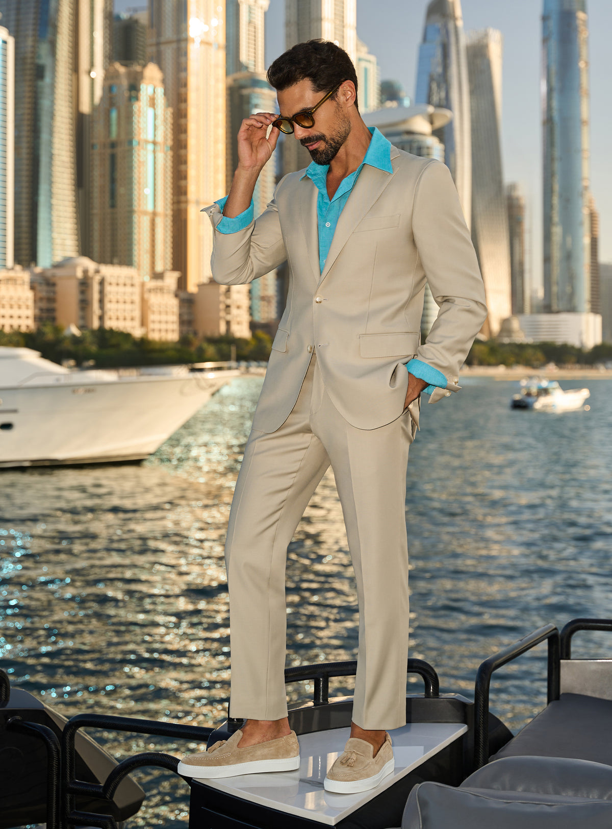Consiglieri Splendor Radiance: cream suit with a turquoise shirt, worn on a yacht deck