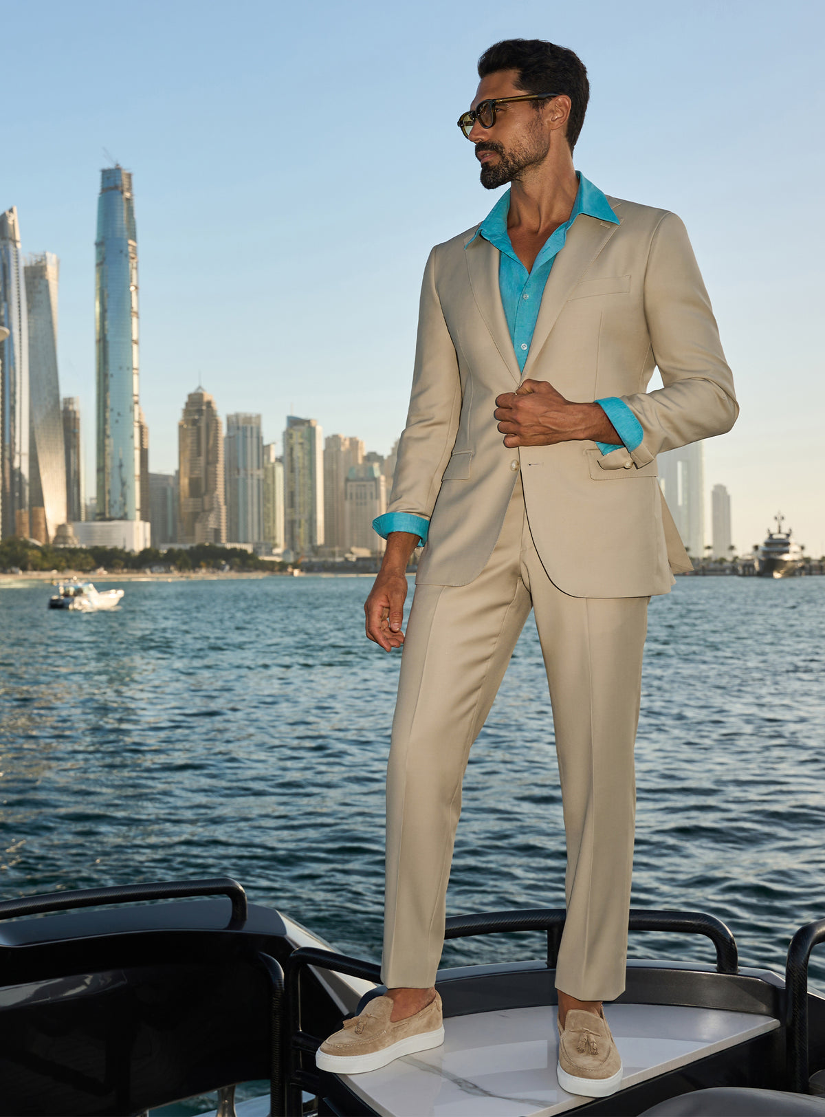 Consiglieri Splendor Radiance: cream suit with a turquoise shirt, worn on a yacht deck