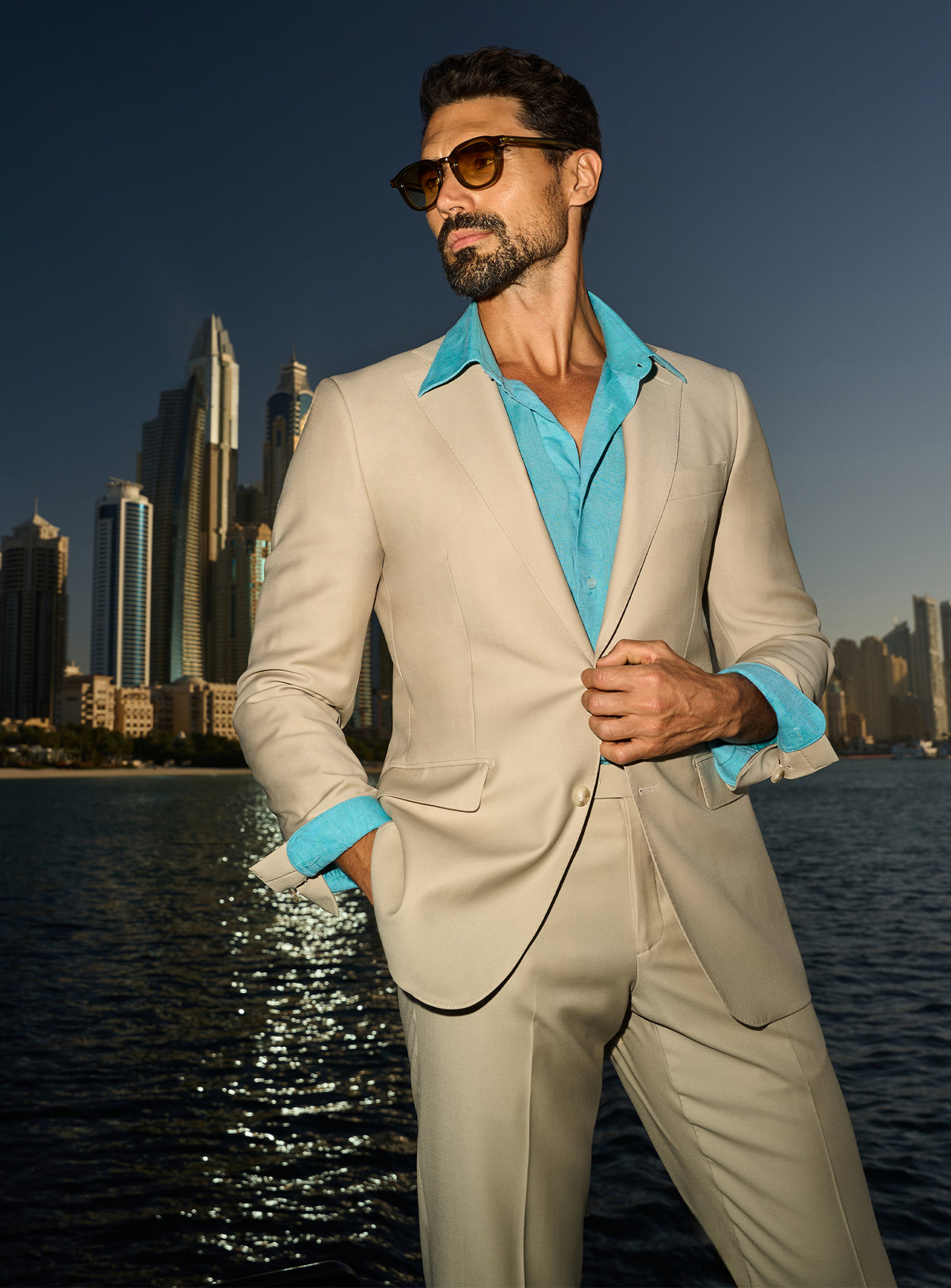 Consiglieri Splendor Radiance: cream suit with a turquoise shirt, worn on a yacht deck