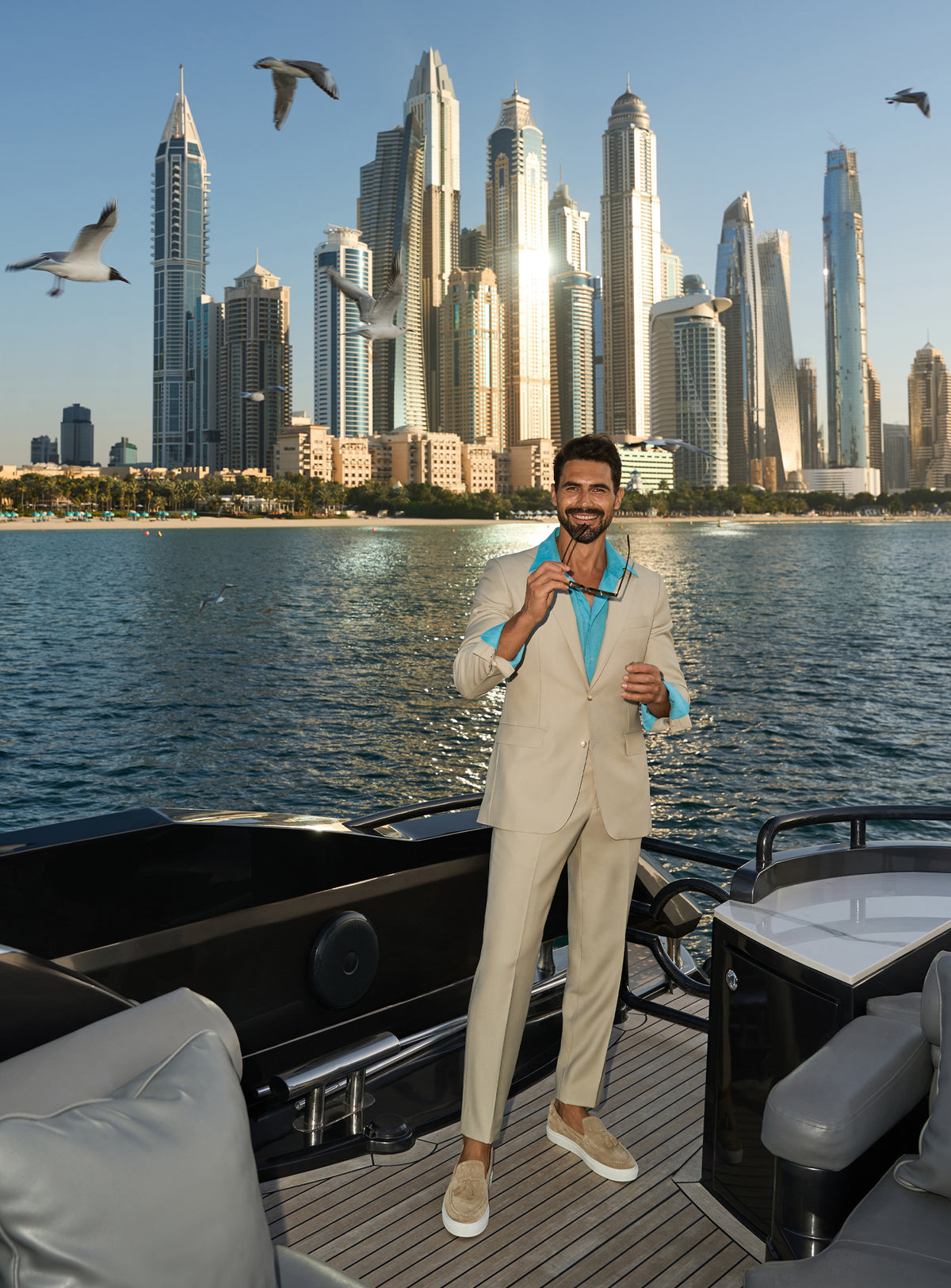 Consiglieri Splendor Radiance: cream suit with a turquoise shirt, worn on a yacht deck