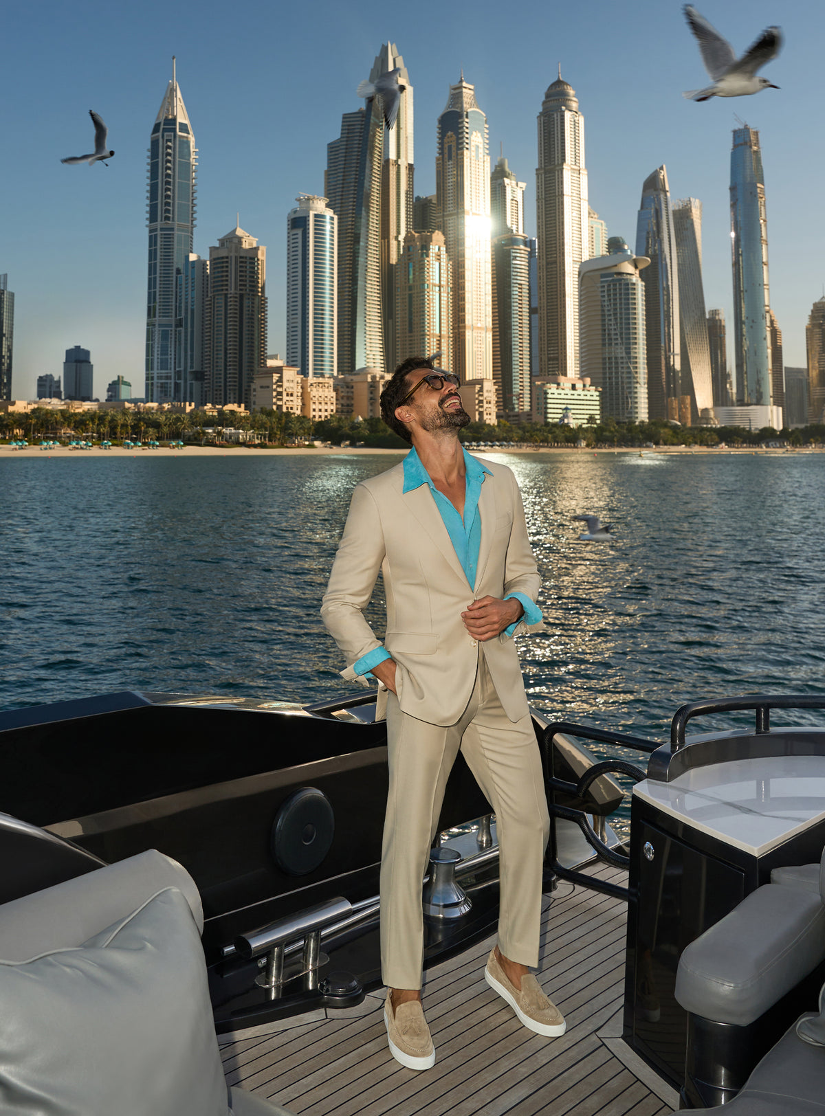 Consiglieri Splendor Radiance: cream suit with a turquoise shirt, worn on a yacht deck