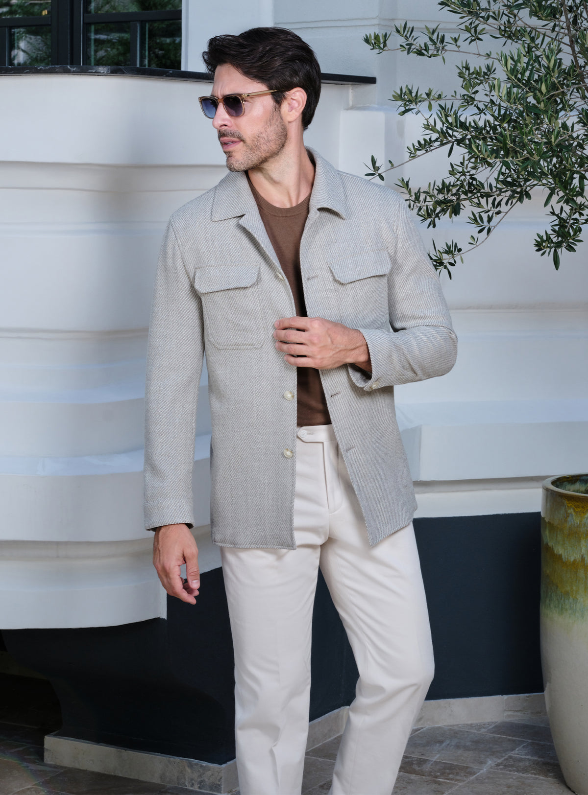 Light beige Consiglieri jacket with flap pockets, a brown sweater and white trousers