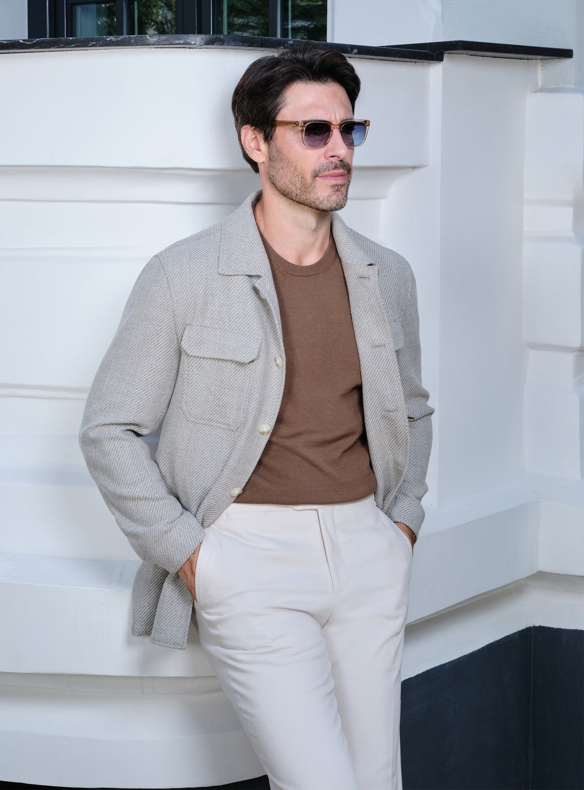 Light beige Consiglieri jacket with flap pockets, a brown sweater and white trousers