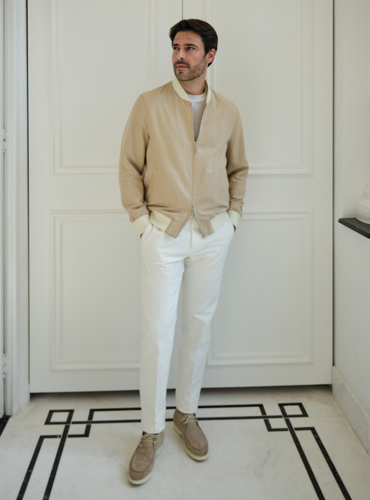 Beige Consiglieri zip bomber jacket worn with white trousers