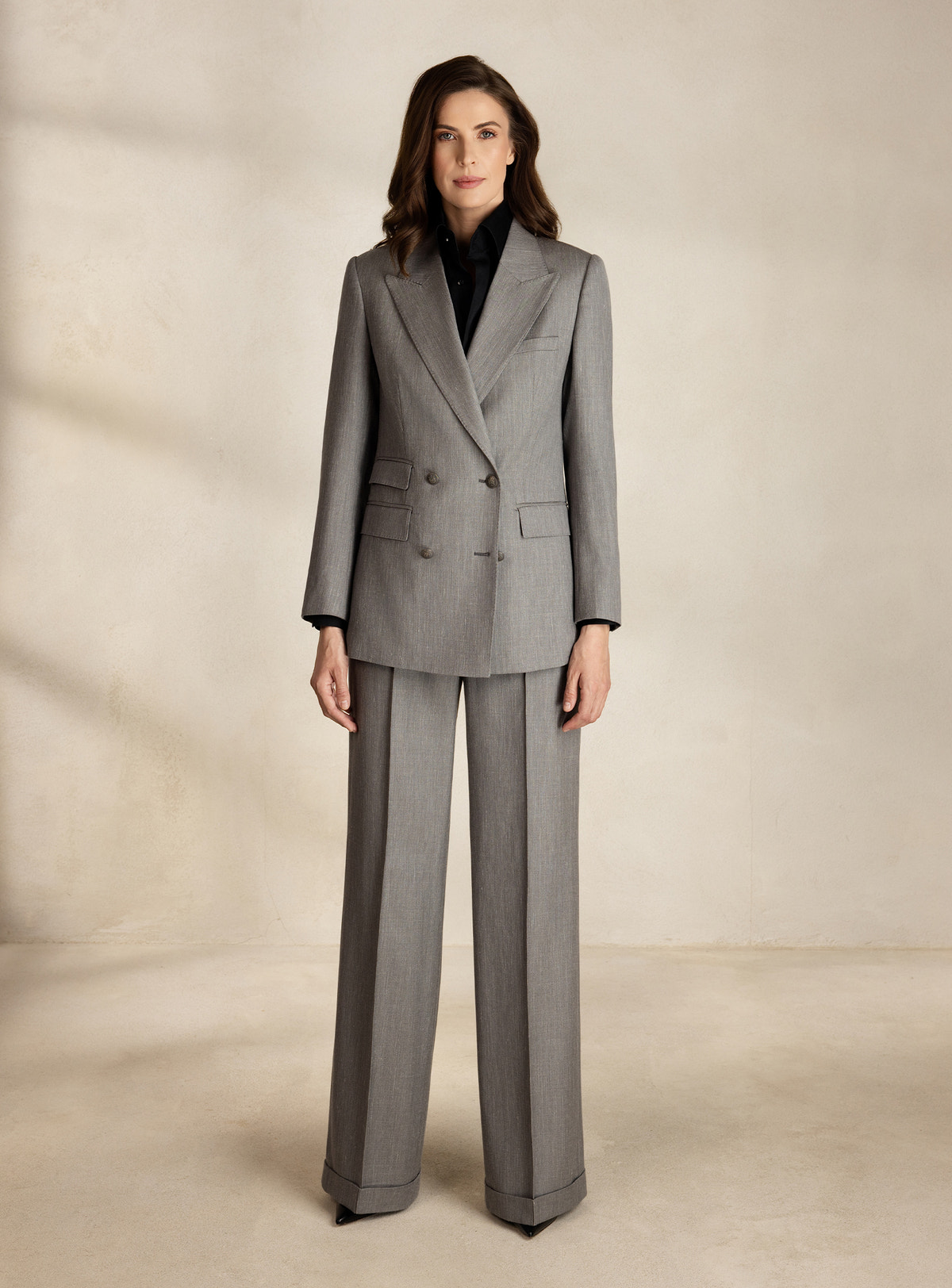 Grey Consiglieri DONNA suit with a double-breasted blazer and wide-leg trousers over a black blouse
