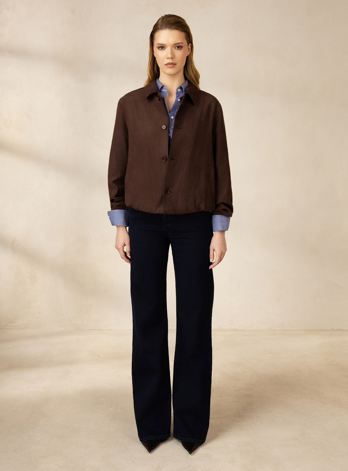 Brown Consiglieri DONNA jacket with a shirt collar, a pale blue shirt and dark jeans