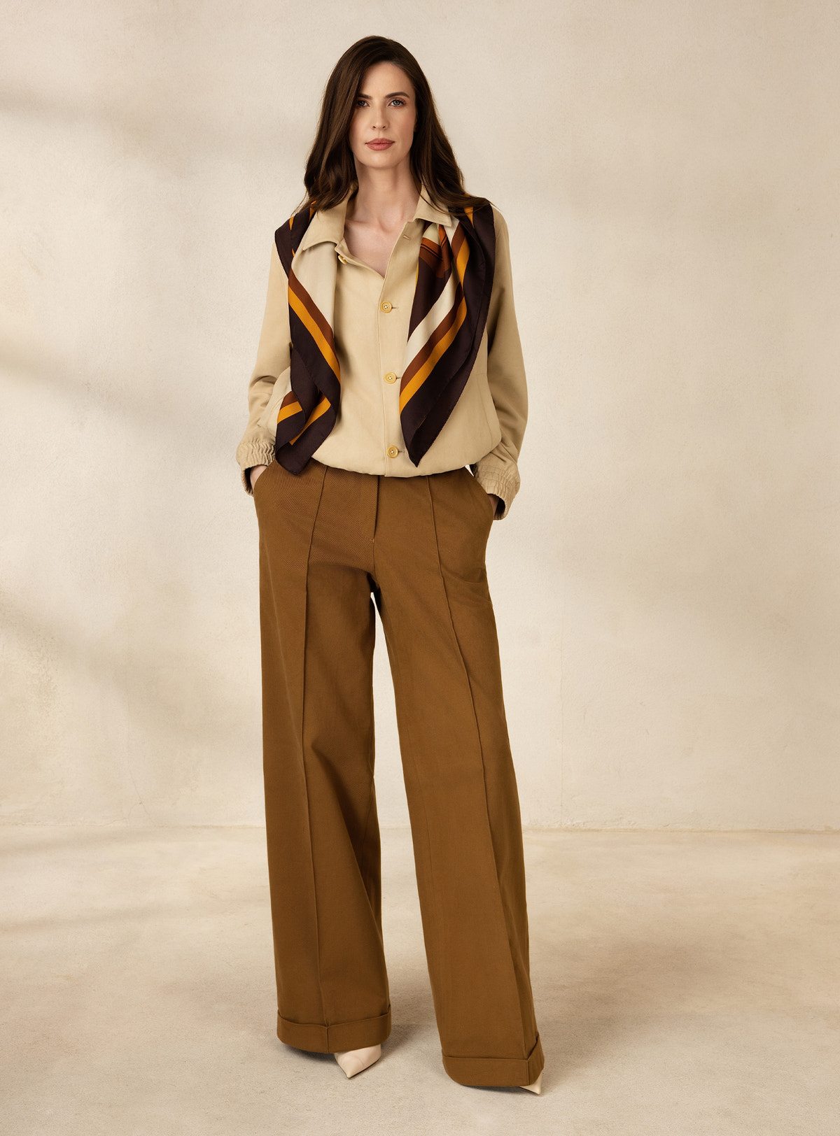 Beige Consiglieri DONNA jacket worn with brown wide-leg trousers and a printed scarf